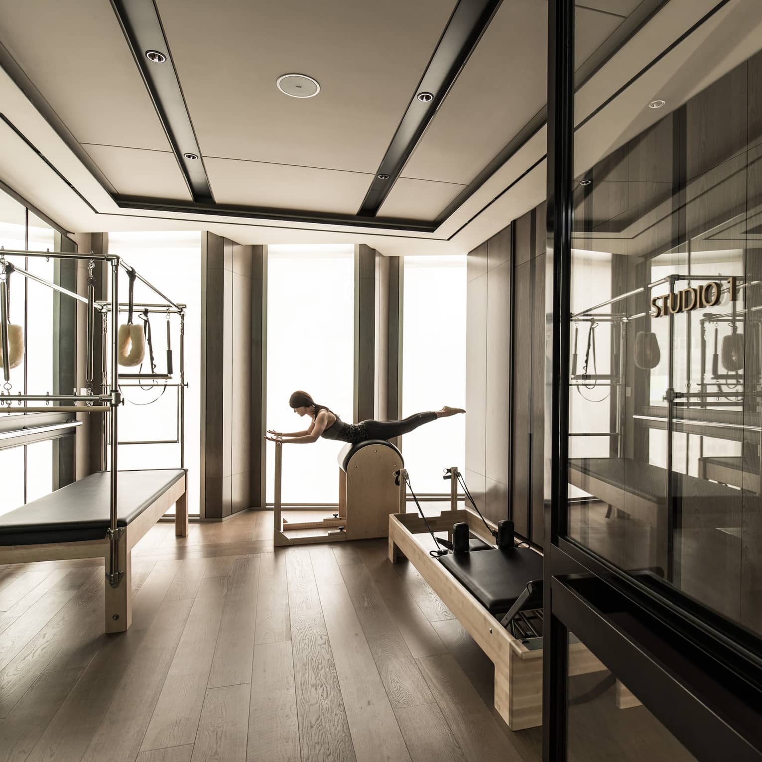 Woman stretches, balances on machine in Fitness Centre near weight station