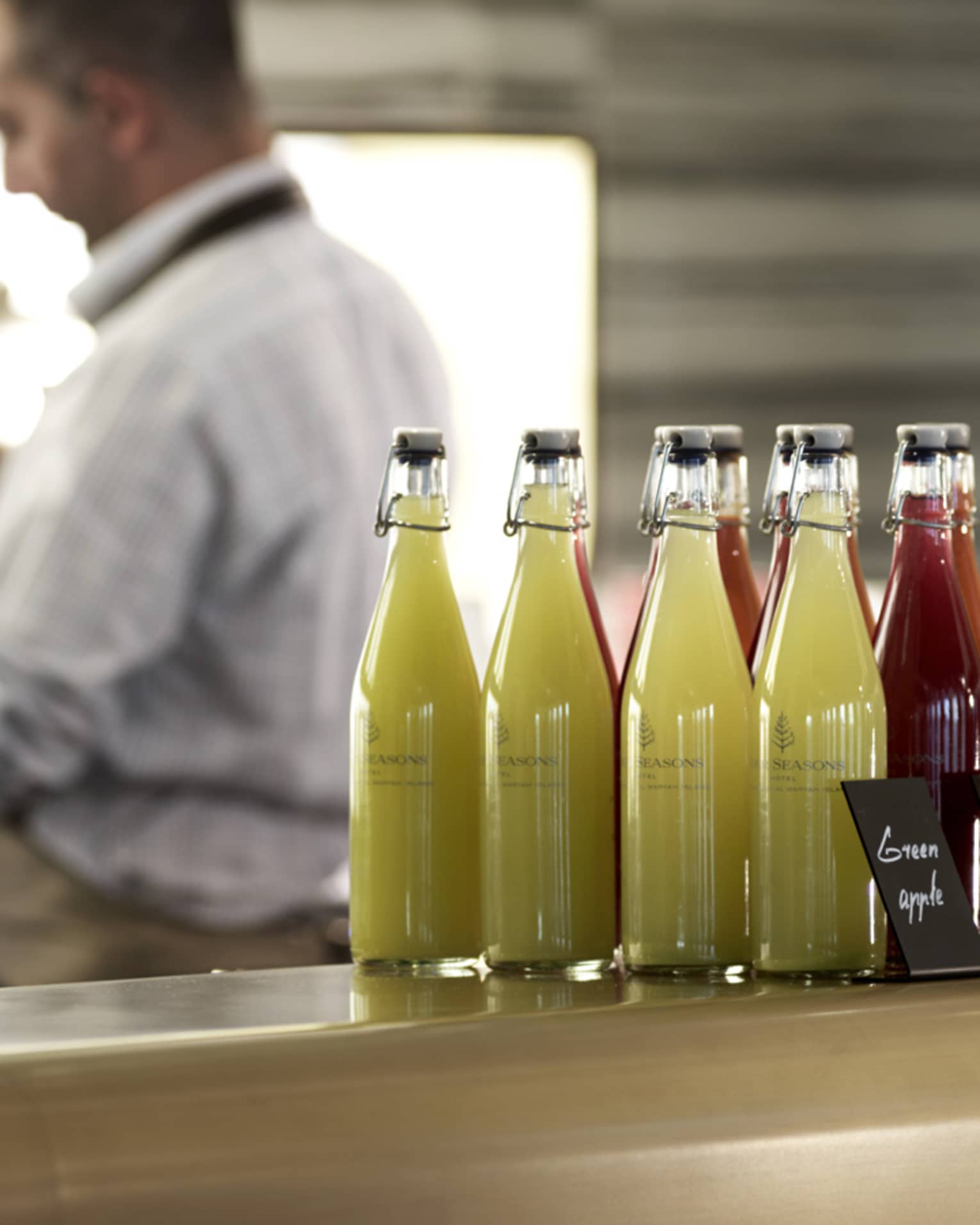 Several pressed juices sealed in glass jars on a countertop. 