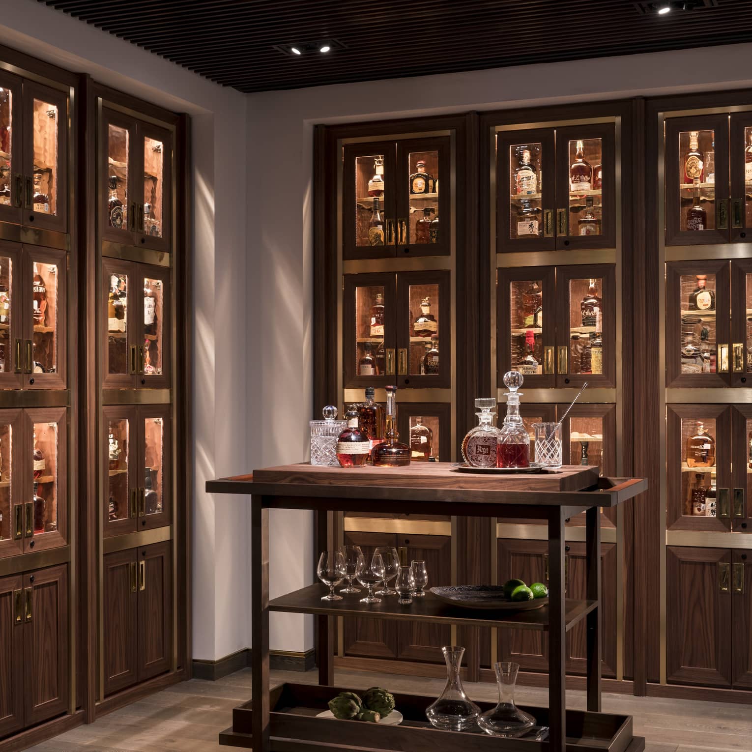 Various whiskey, bourbon, crystal bottles on bar