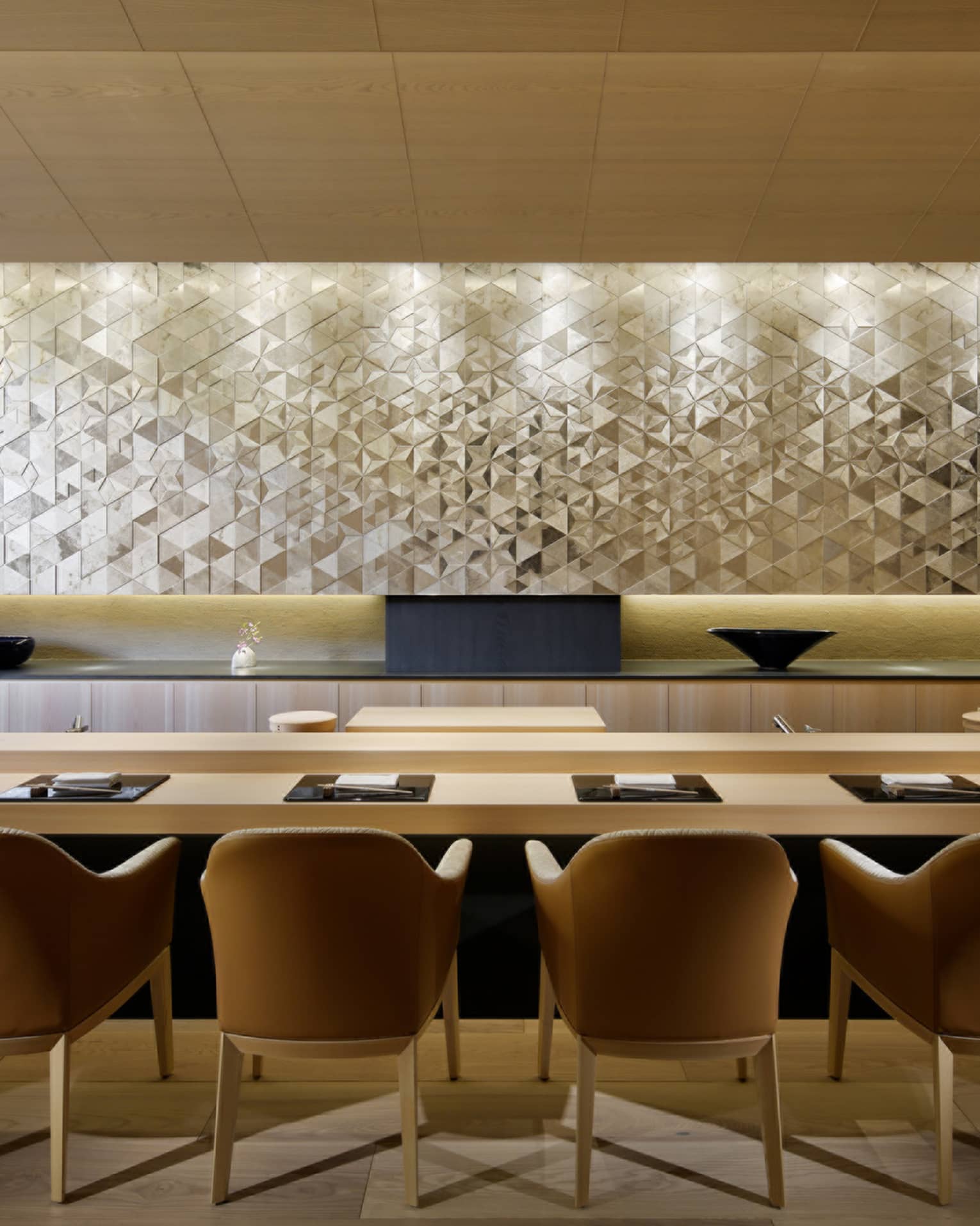 Sushi Wakon large chairs line light wood bar under silver tile wall