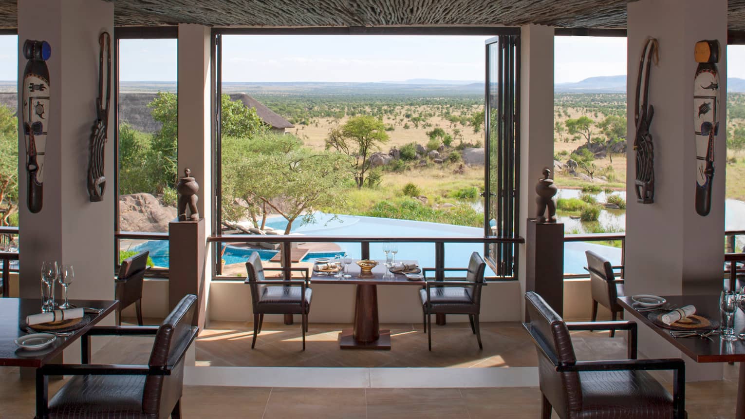 Indoor dining room with Indigenous art, looking down over swimming pool, fields