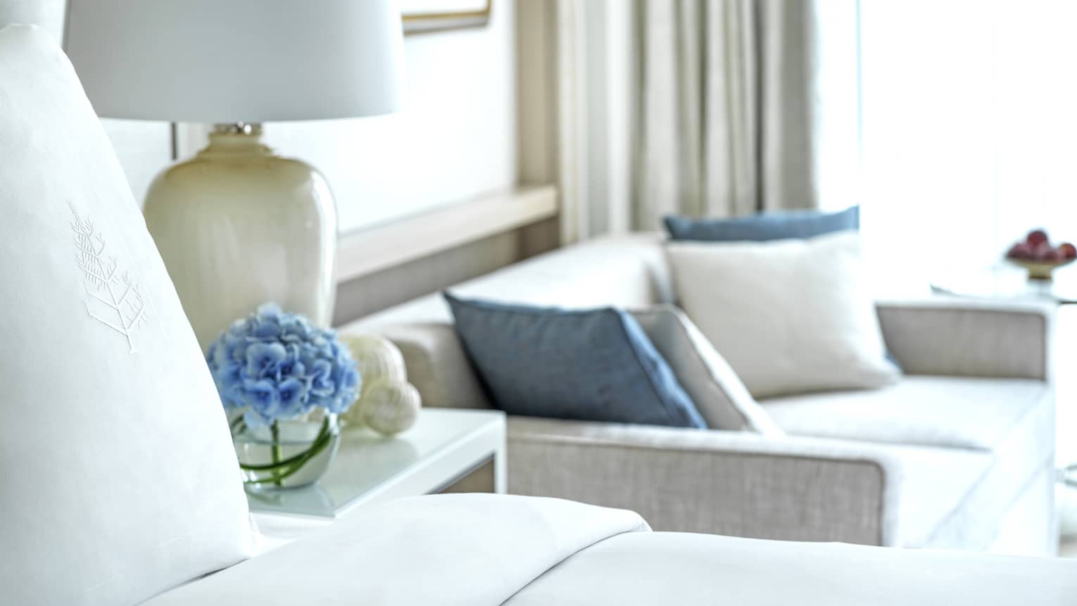 Four Seasons bed, nightstand with lamp, and two-seat sofa