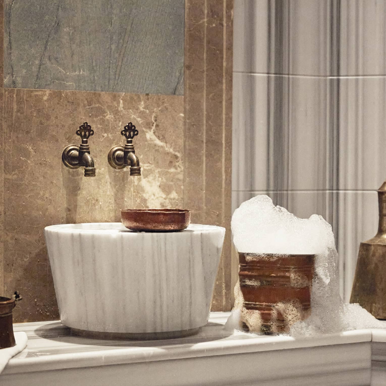 A luxurious sink and golden bucket with bubbles.