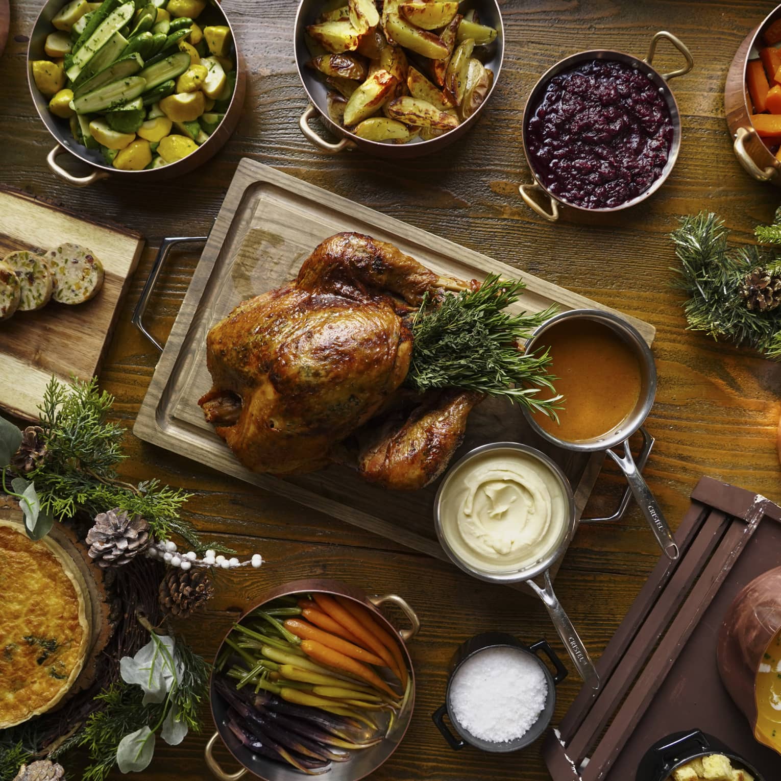 A full festive feast with a Turkey in the centre, and several copper pots of stewed vegetables surrounding