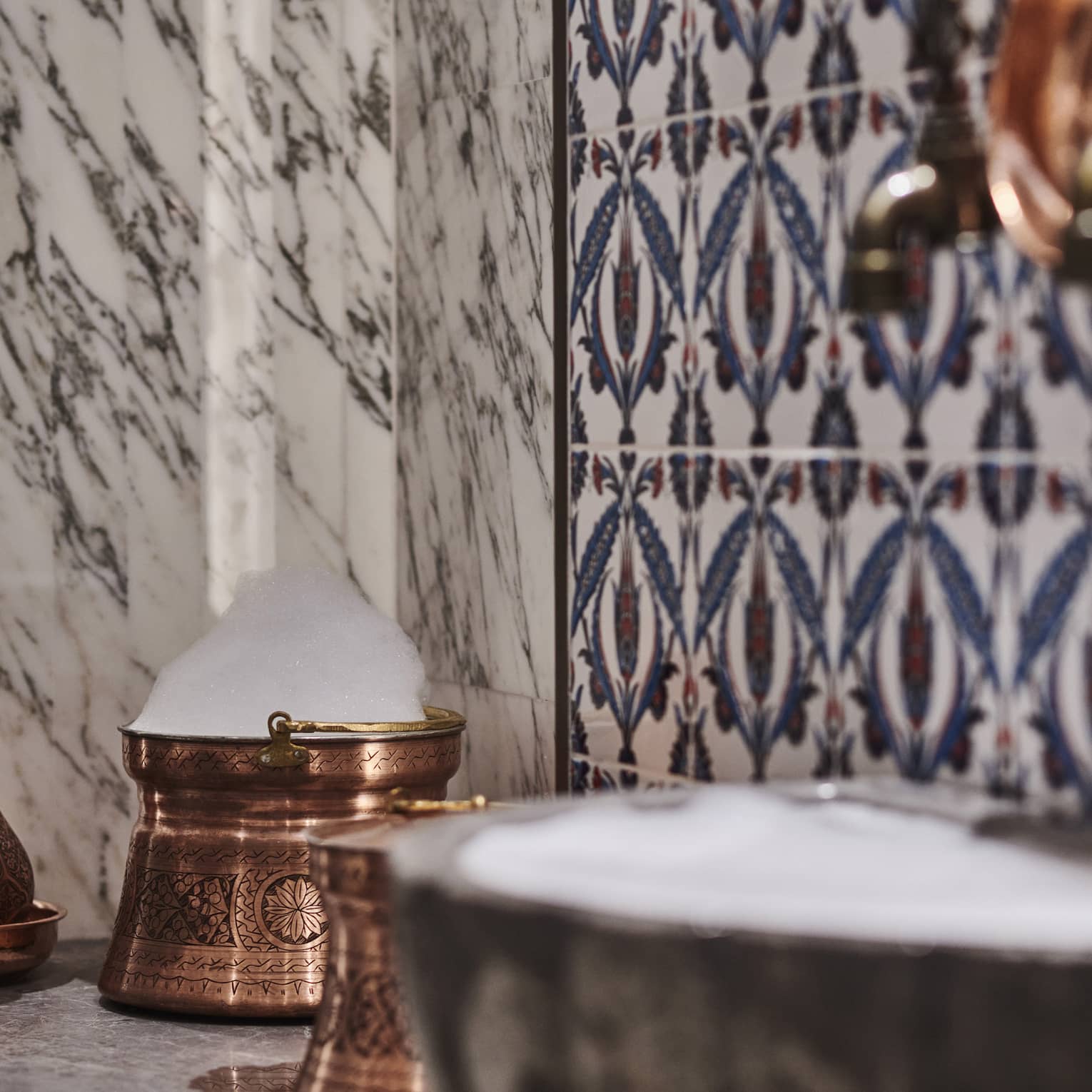Kuma Spa tiles and marble walls by copper sink
