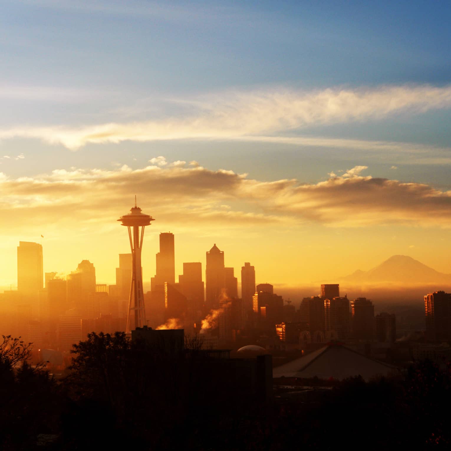The sun sets over the silhouette of Seattle