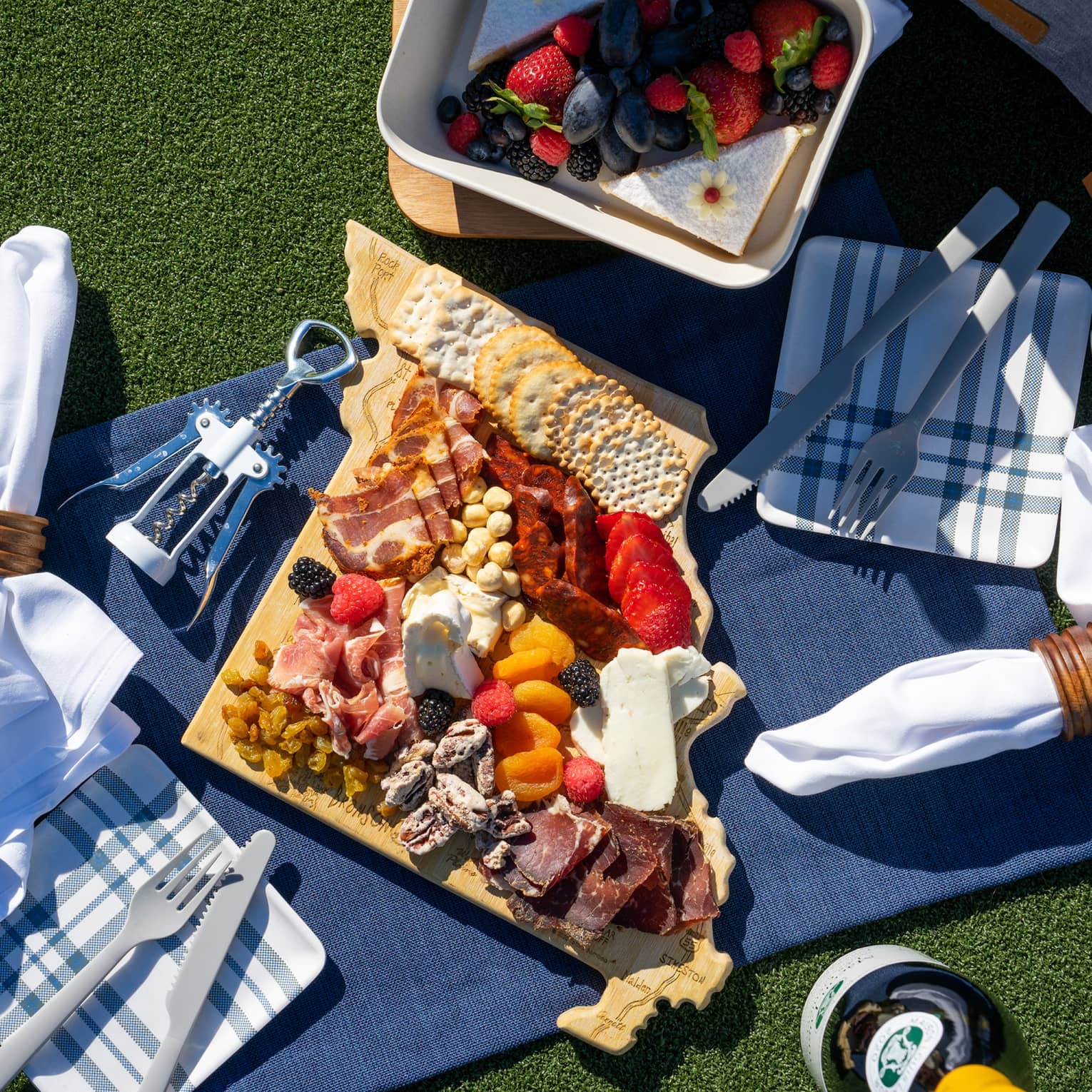 A picnic blanket covered in charcuterie.