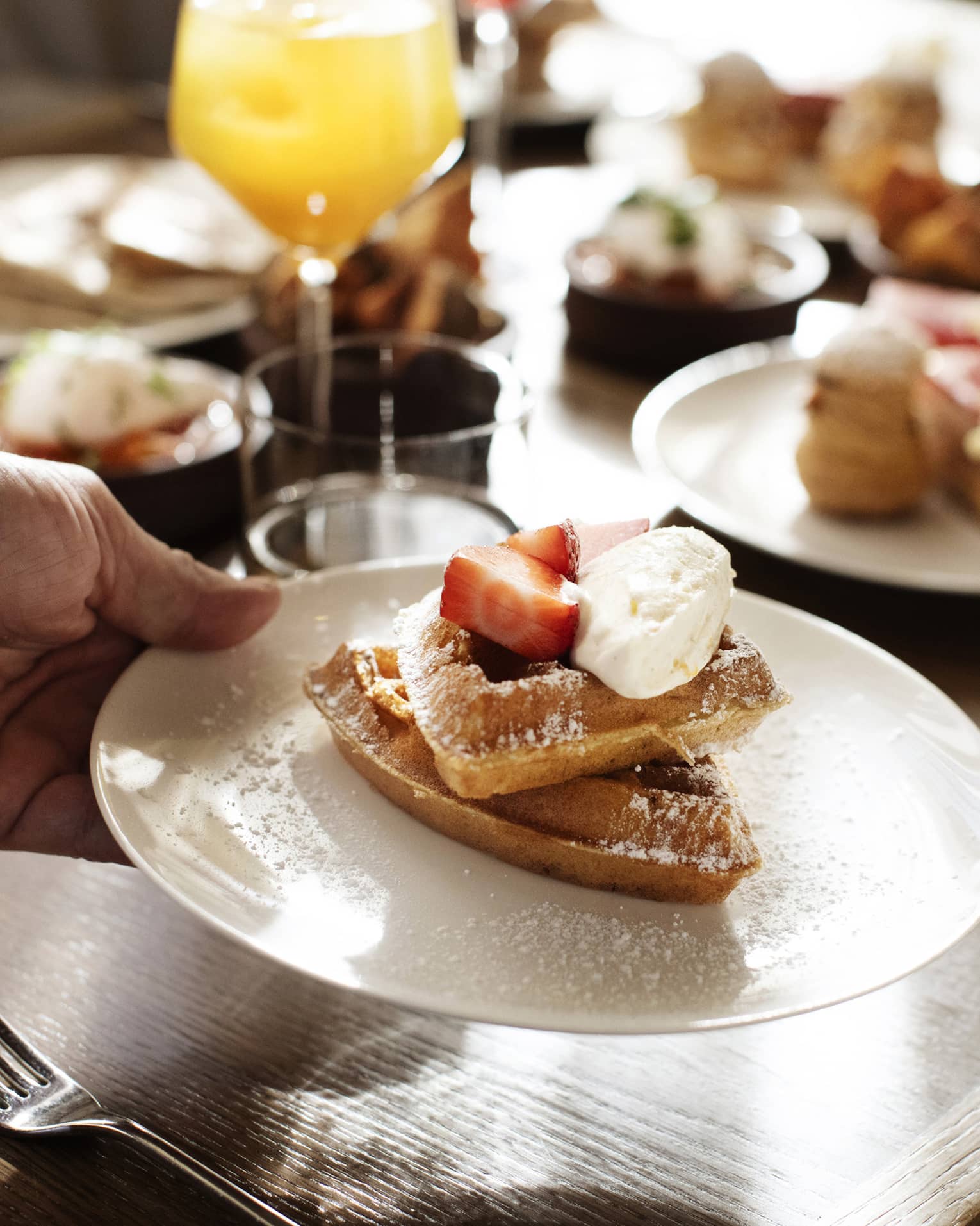 Waffles with strawberries and whipped cream on top.