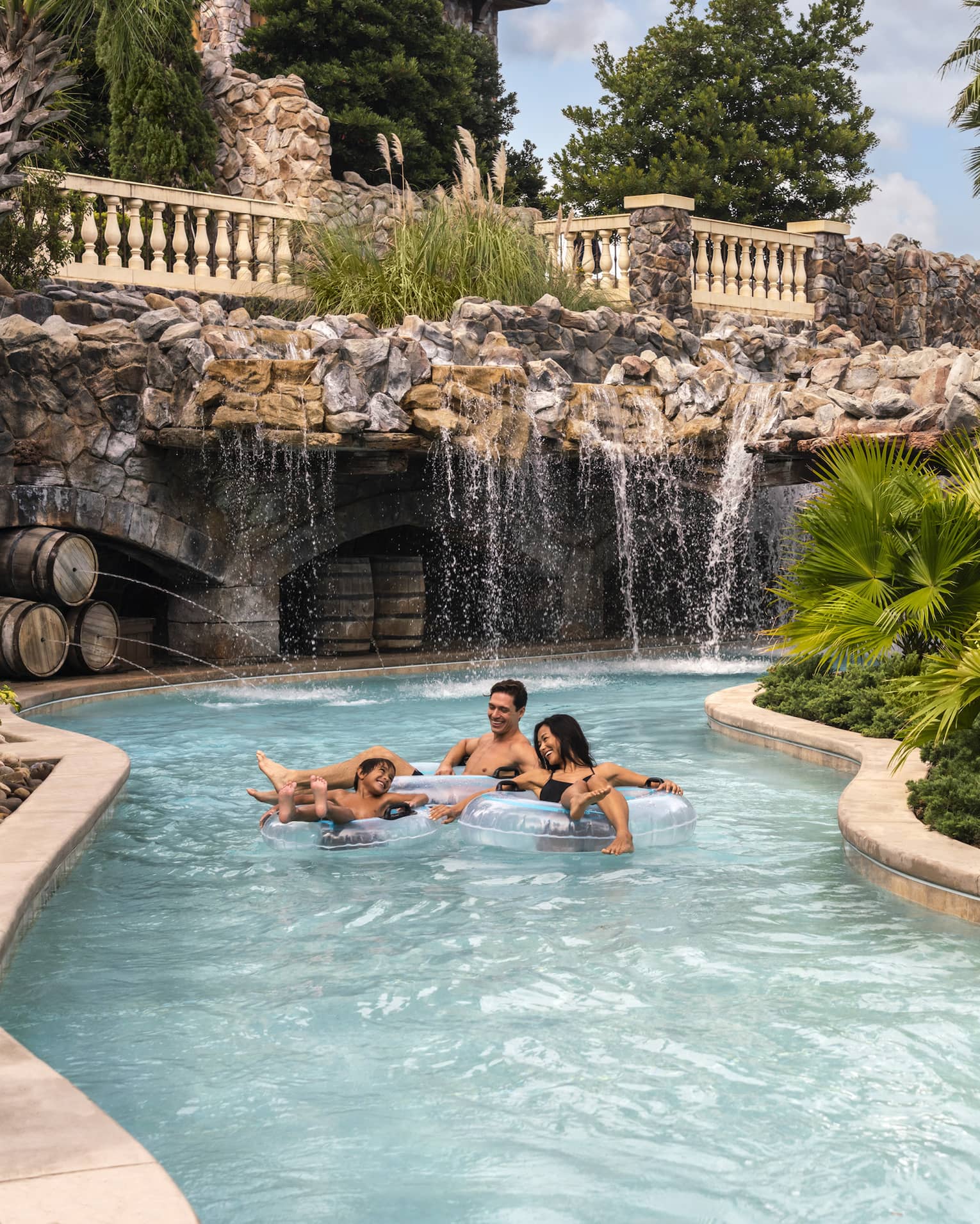 Two adults and a child ride in light-blue inner tubes along the Resort's outdoor lazy river