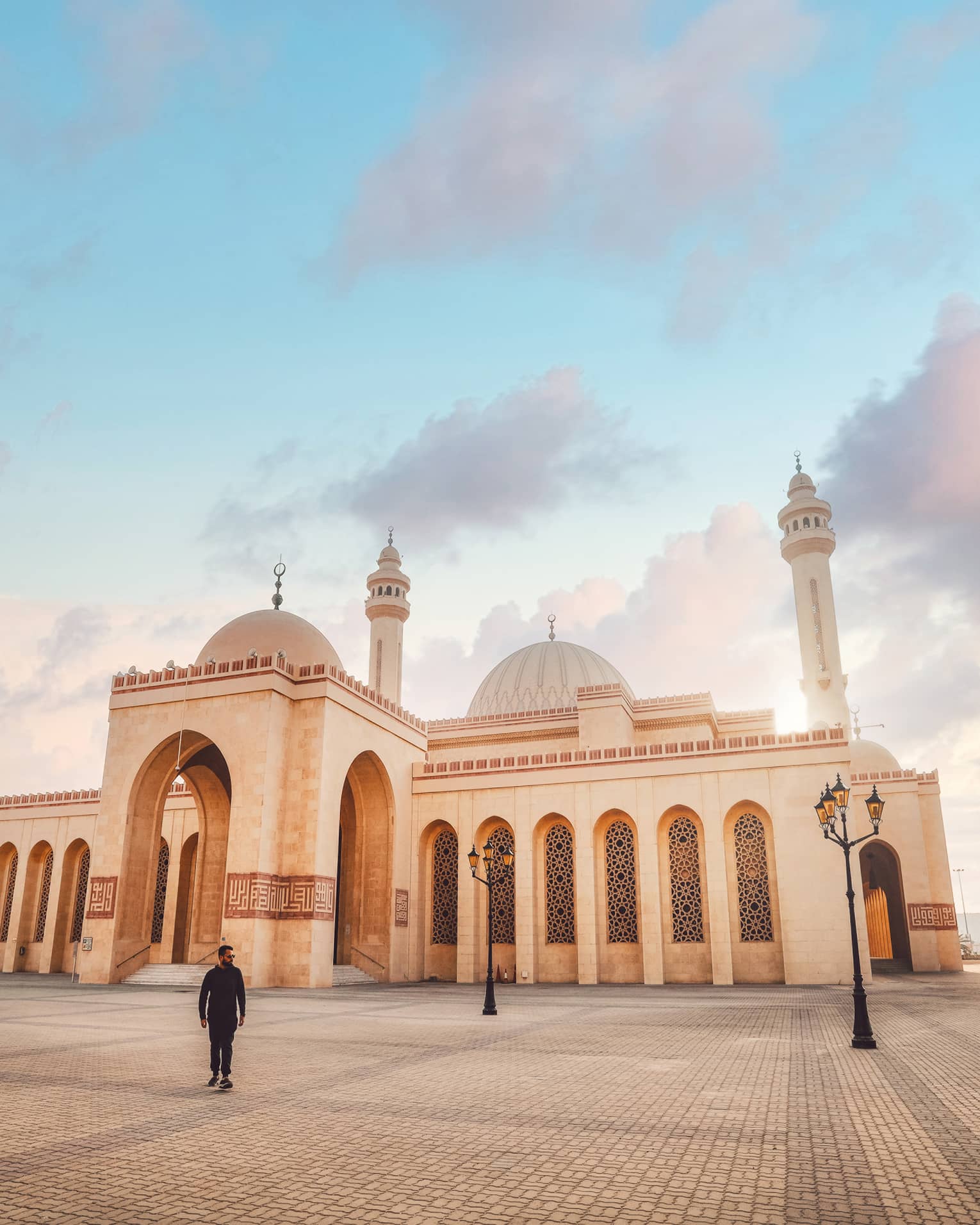 A large tan mosque with several pillars.