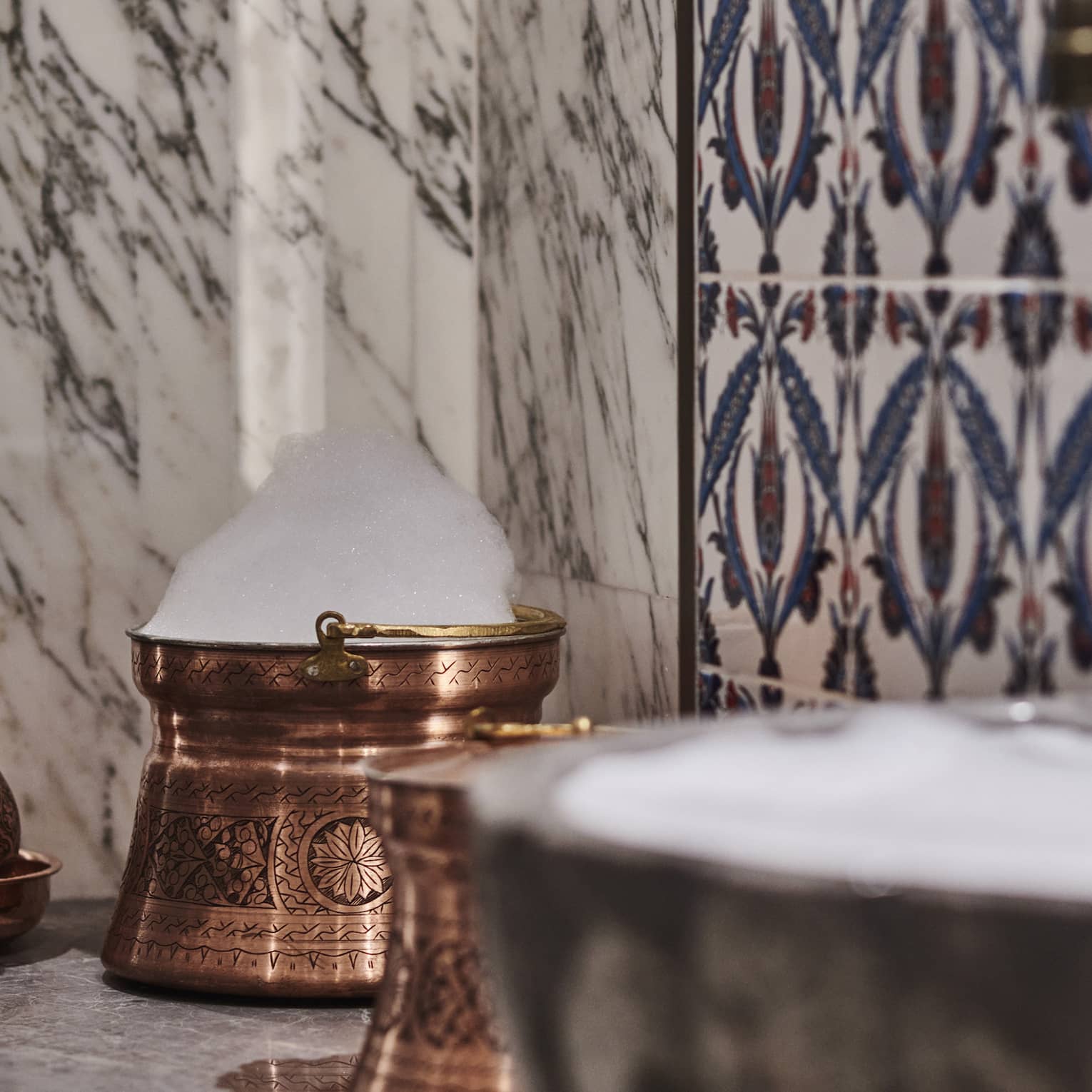 Kuma Spa tiles and marble walls by copper sink