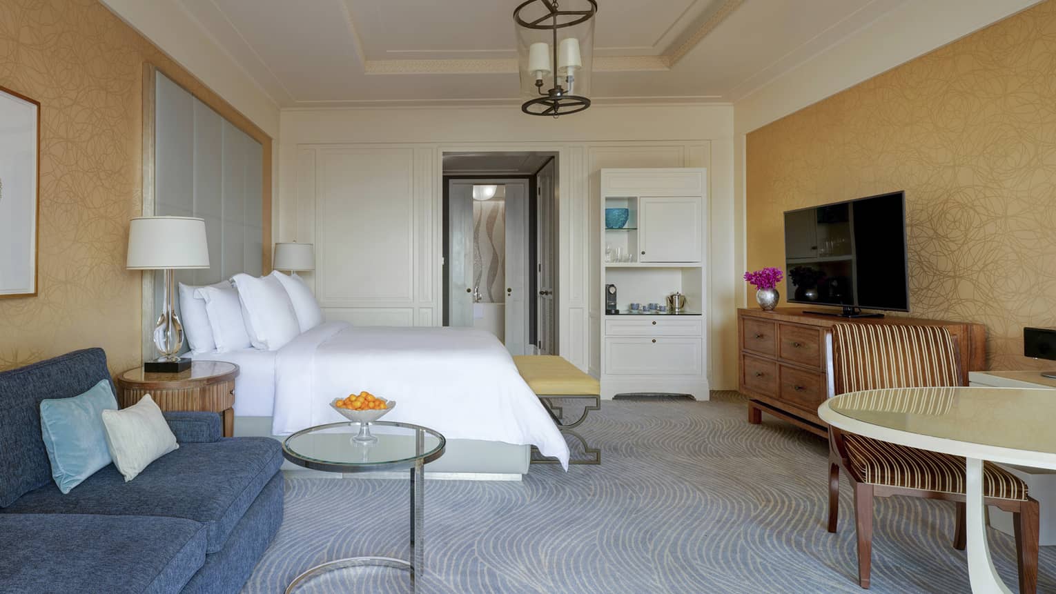 Bedroom with bed, table and chairs, dark blue sofa