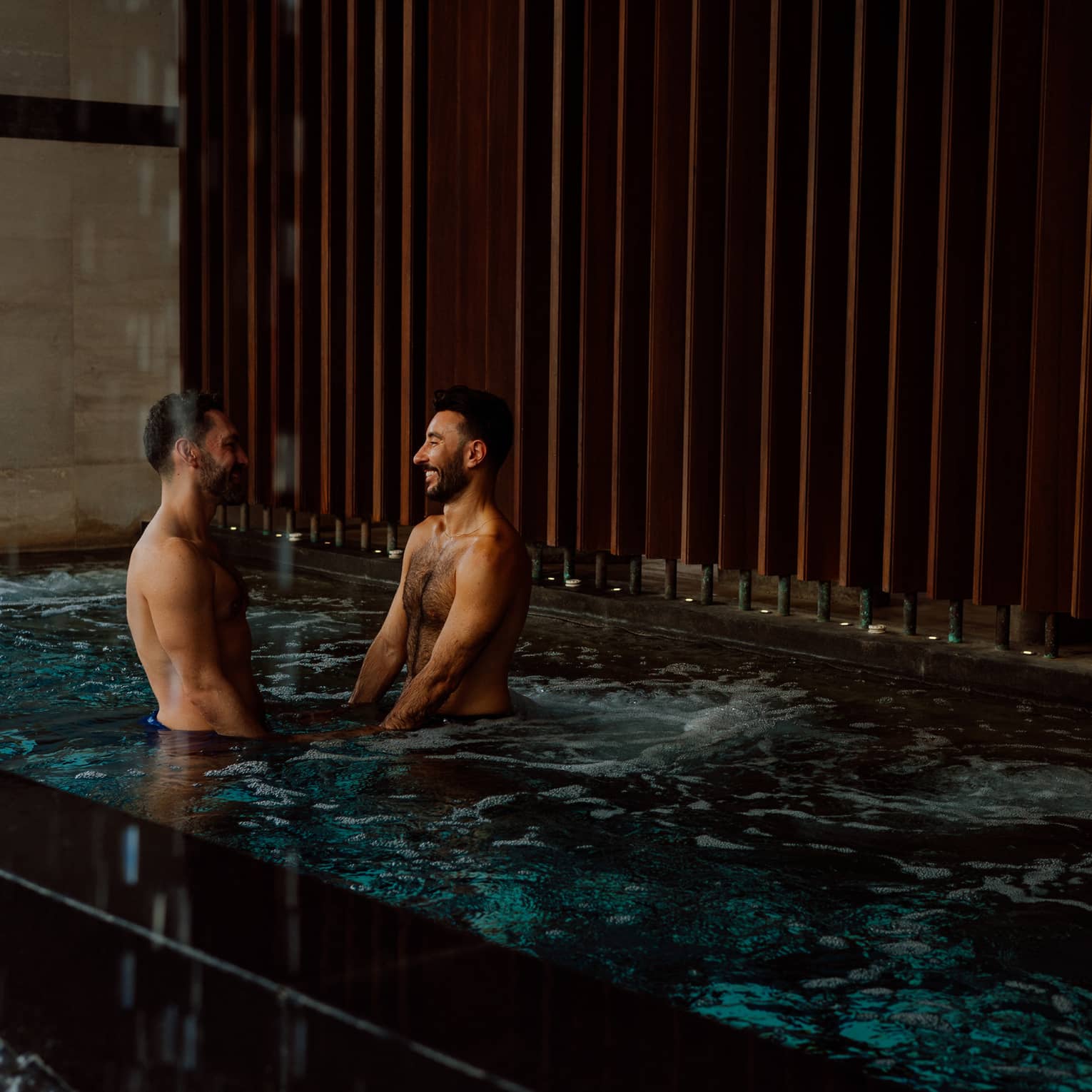 A couple stands in a spa pool together
