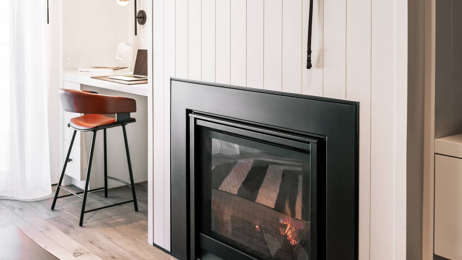 Fireplace built into off-white wall, wood floors, built-in desk and shelves
