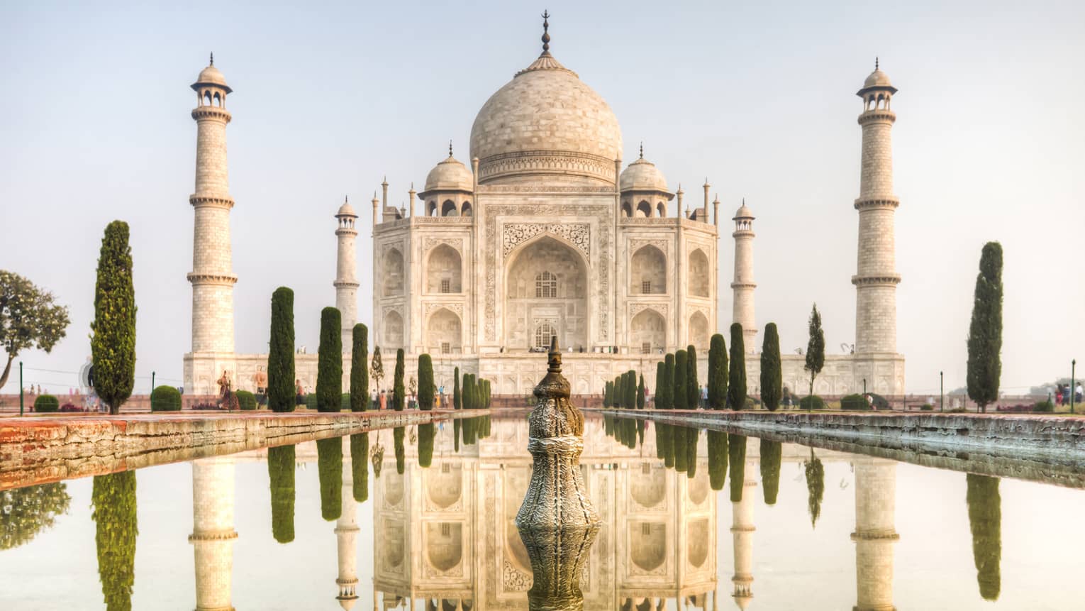 Clear water mirrors the reflection of the Taj Mahal