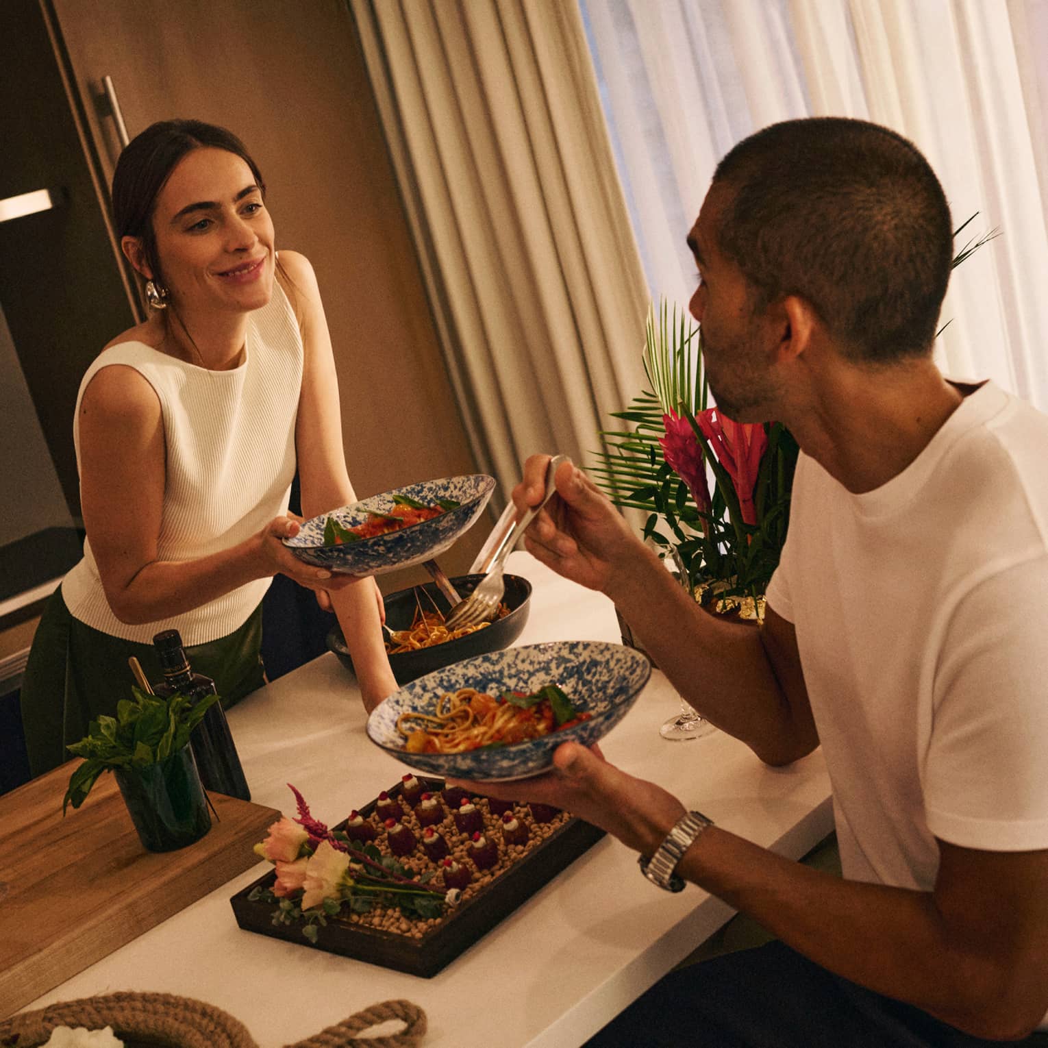 A couple sits at a kitchen island sharing food