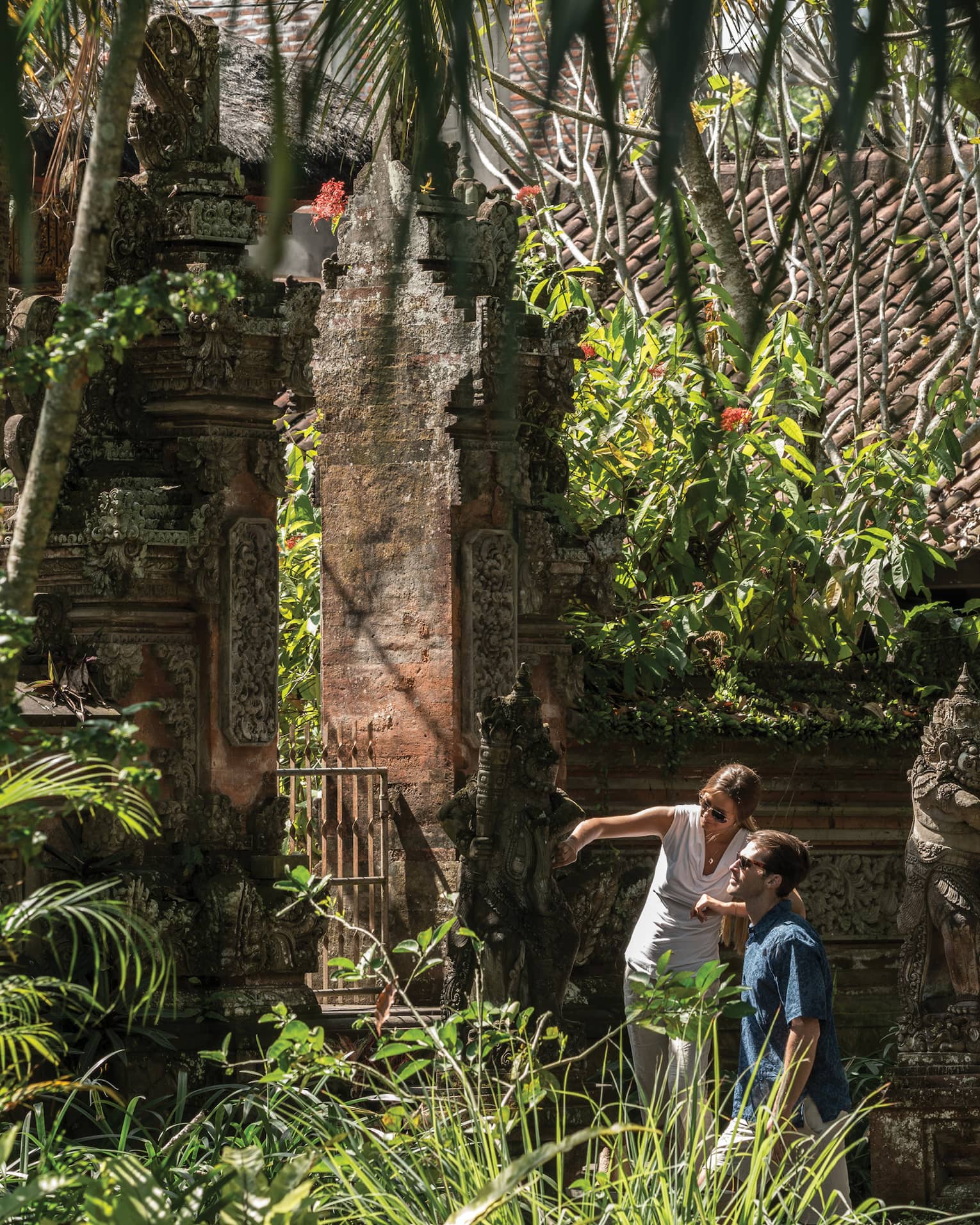 Gusts exploring decorative statues surrounding a temple in Bali