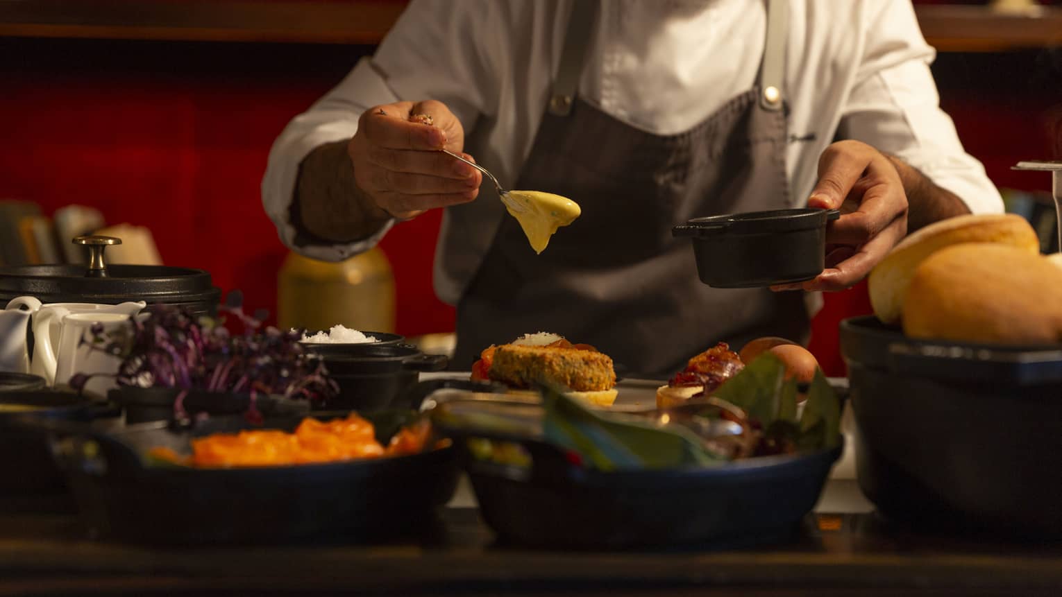 Chef spoons sauce over dish at The Grill Saturday Brunch