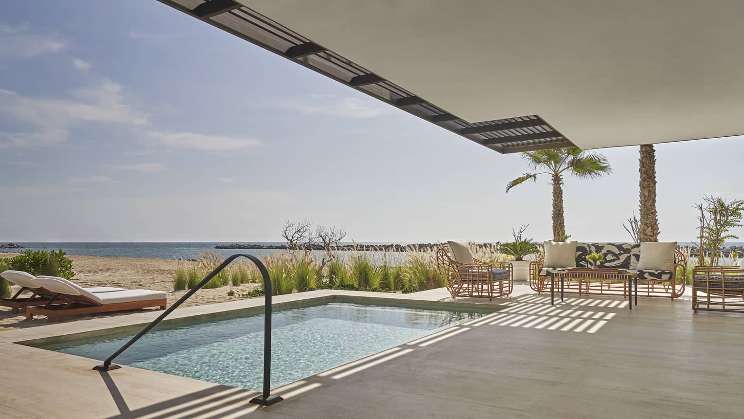 Two Bedroom Sunrise Suite Pool with two lounge chairs, two arm chairs and sofa, ocean views