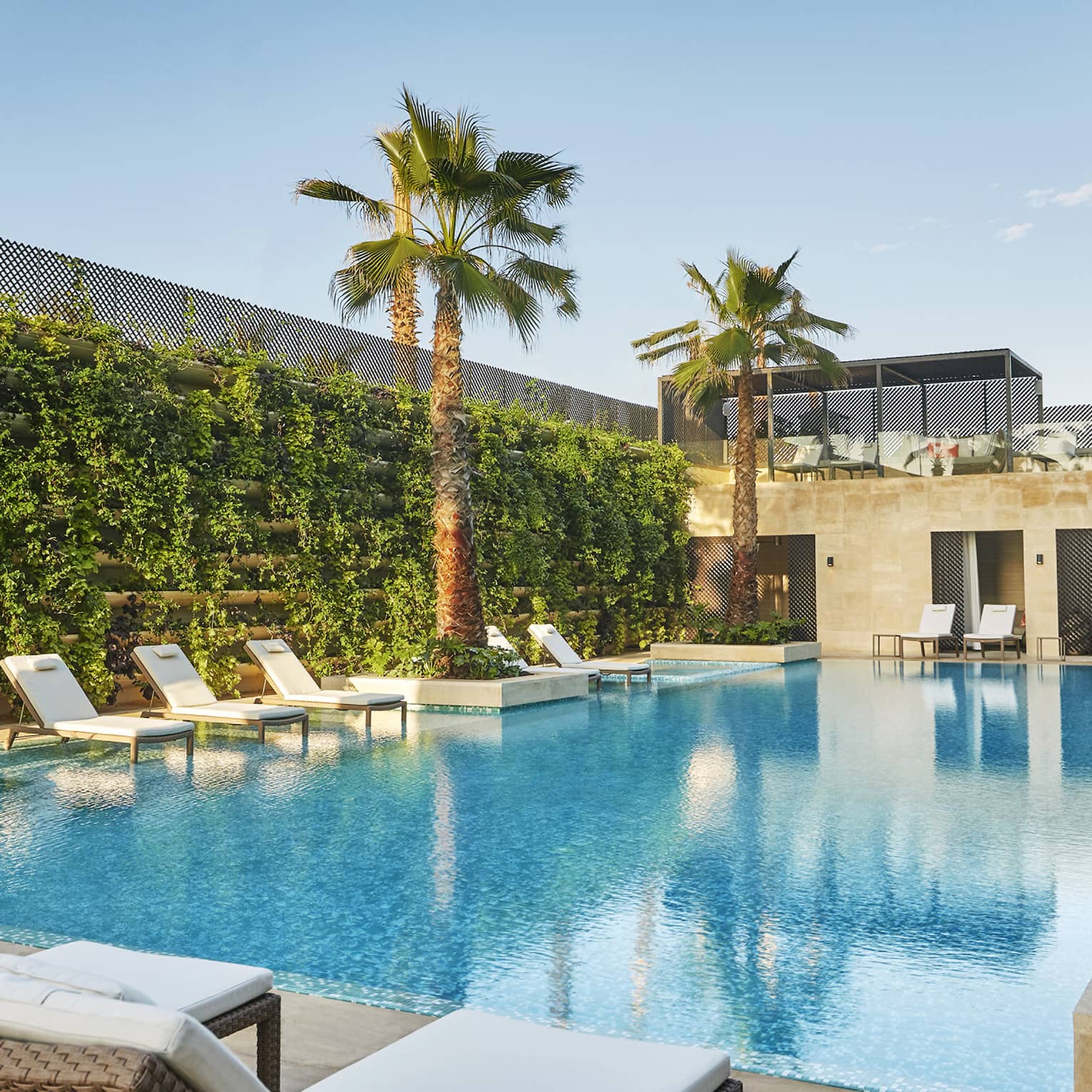 The Moroccan-style pool and lounge framed by thriving greenery and palm trees