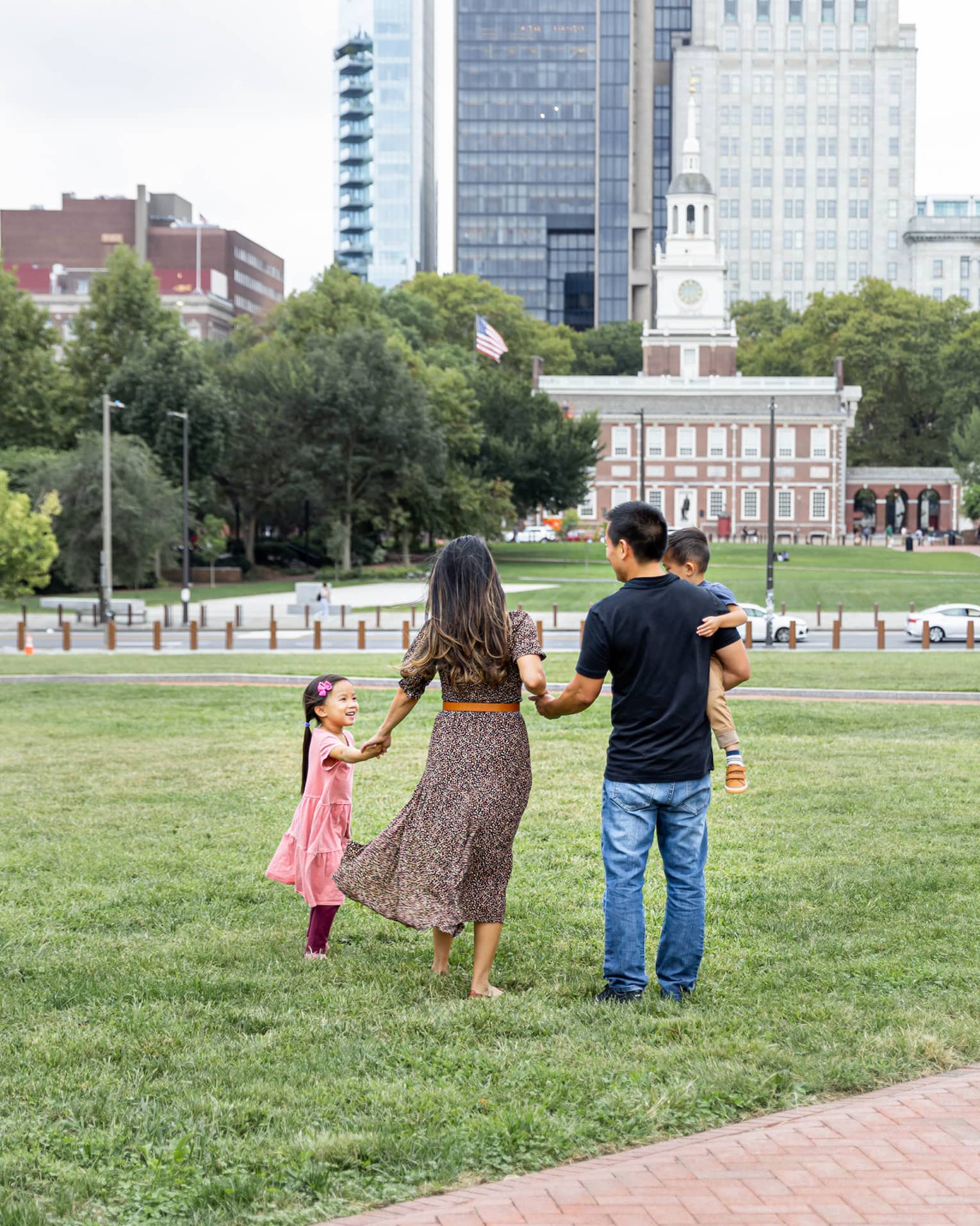 A family of four standing in a park in a city.