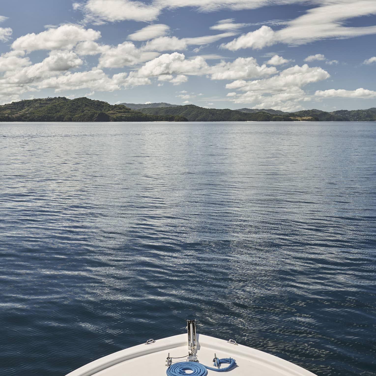 The front edge of a boat looking at water.