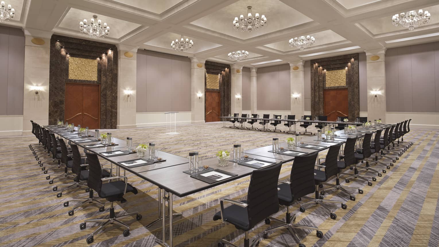 A series of black tables and chairs set up in a semi-circle.
