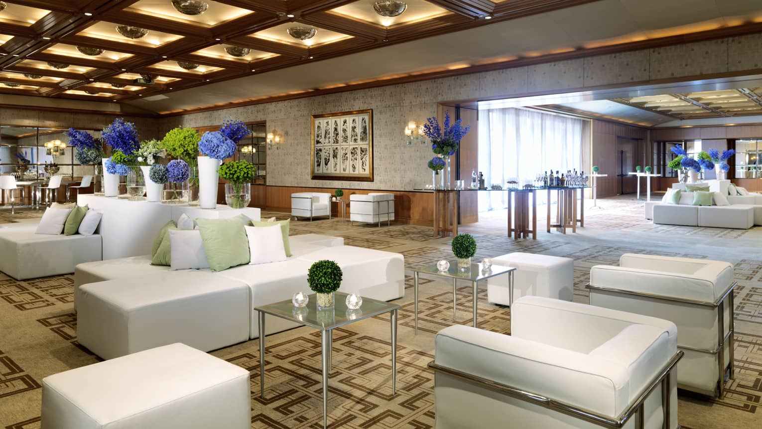 Modern white sofas, chairs arranged in large ballroom
