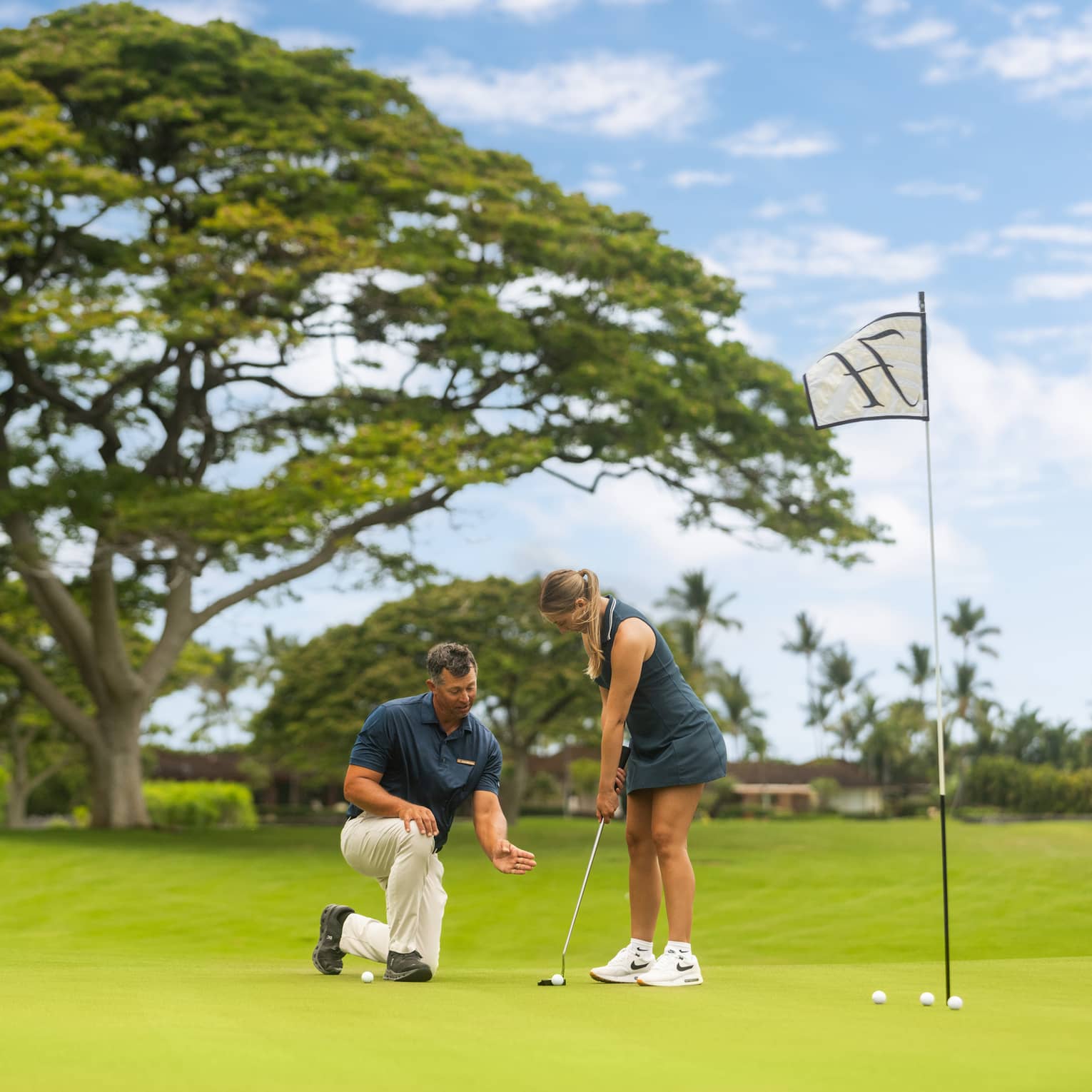 A woman practices her putting during a golf lesson.