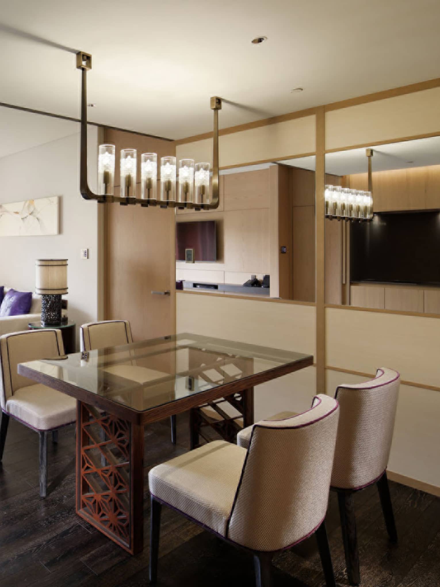 Spacious living and dining area with a glass dining table, chairs, a comfortable seating area and sliding doors opening to a balcony with garden view