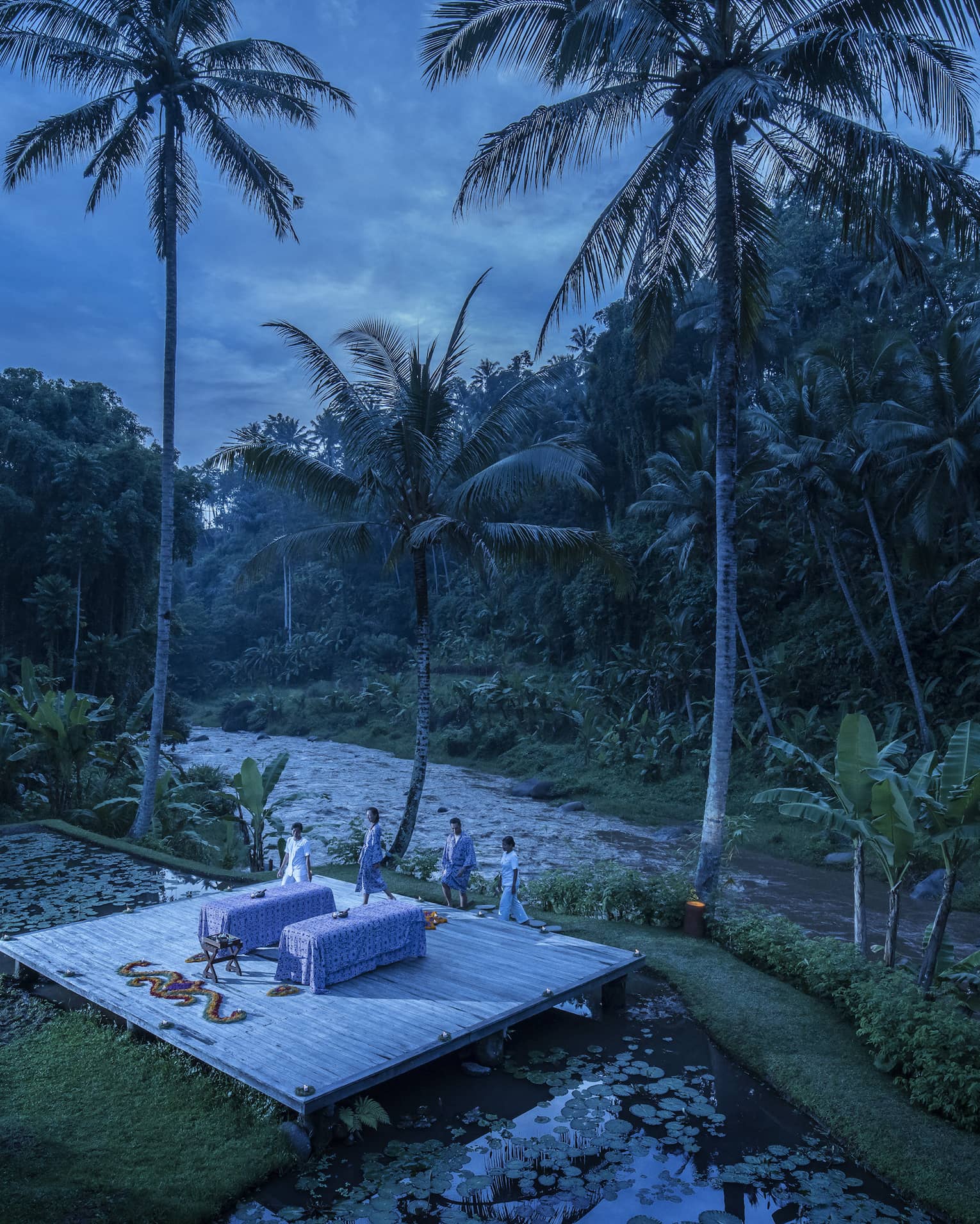 A few wellness experts preparing for a private outdoor treatment at dawn