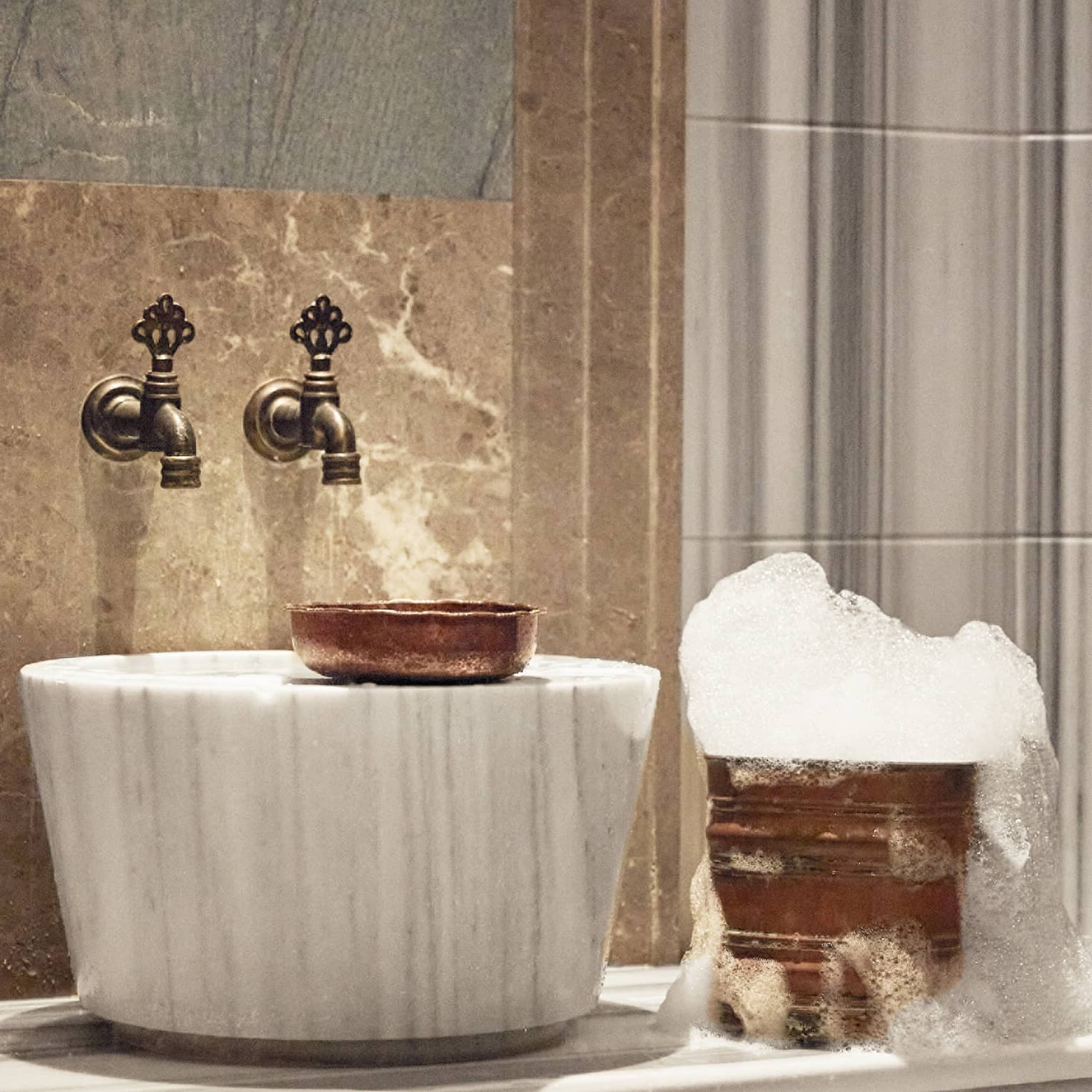 A luxurious sink and golden bucket with bubbles.