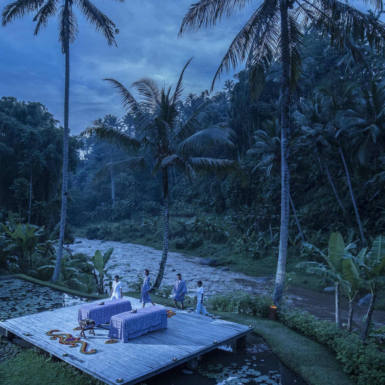A few wellness experts preparing for a private outdoor treatment at dawn