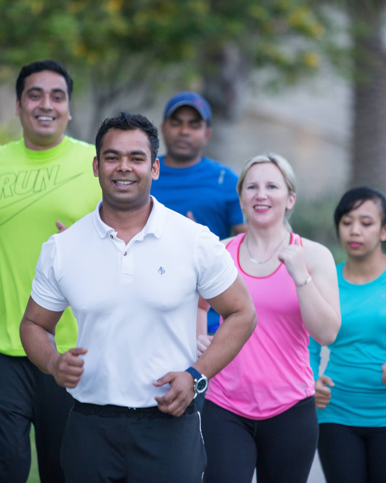 Group of six people wearing workout clothing, jogging