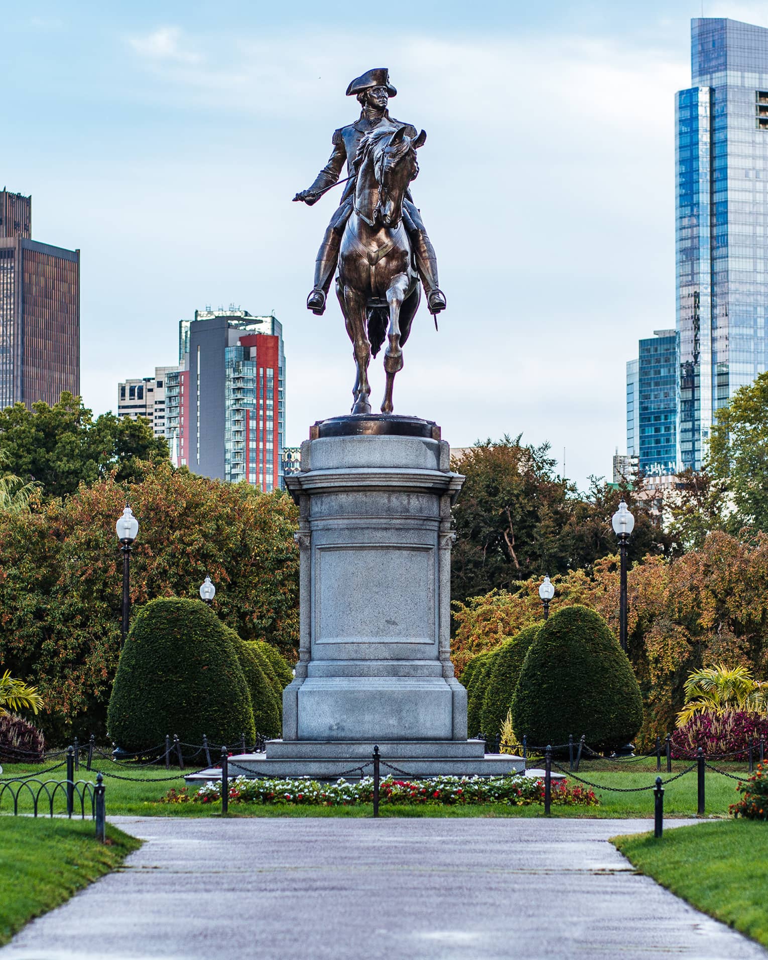 A large statue of a man on horseback in the middle of a garden.