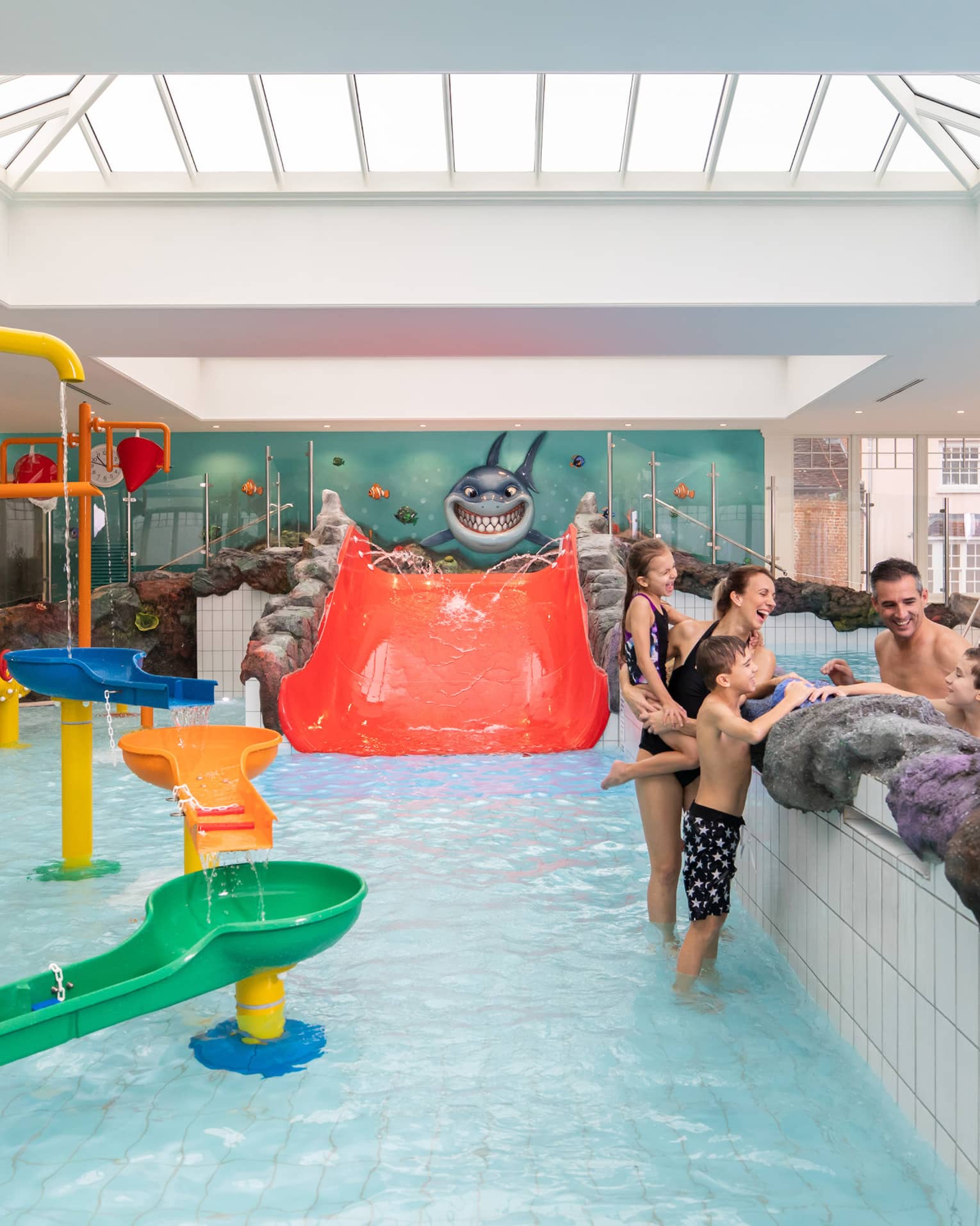Family talking while standing in Sharkie's colourful indoor pool