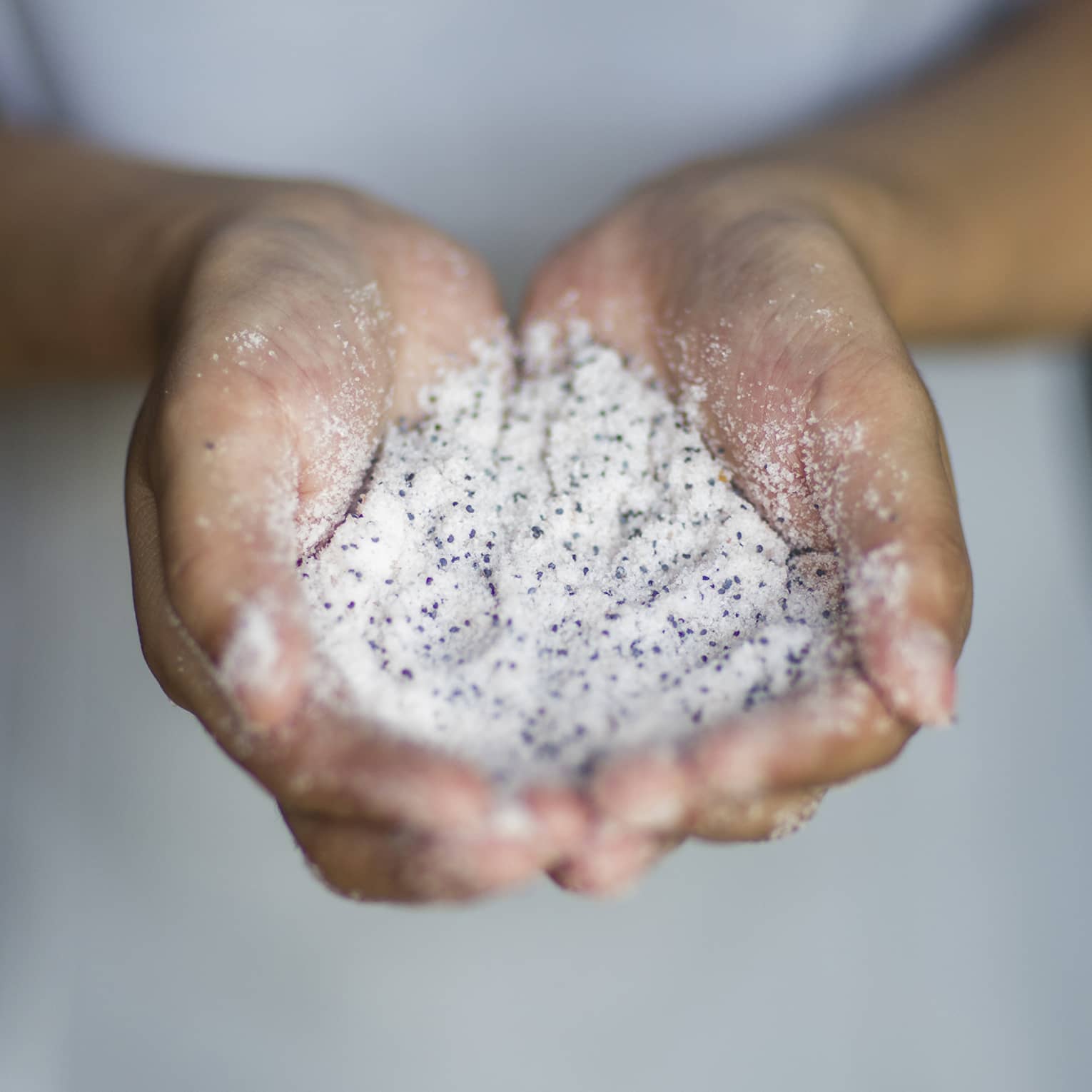 A woman holding sand in her hands.