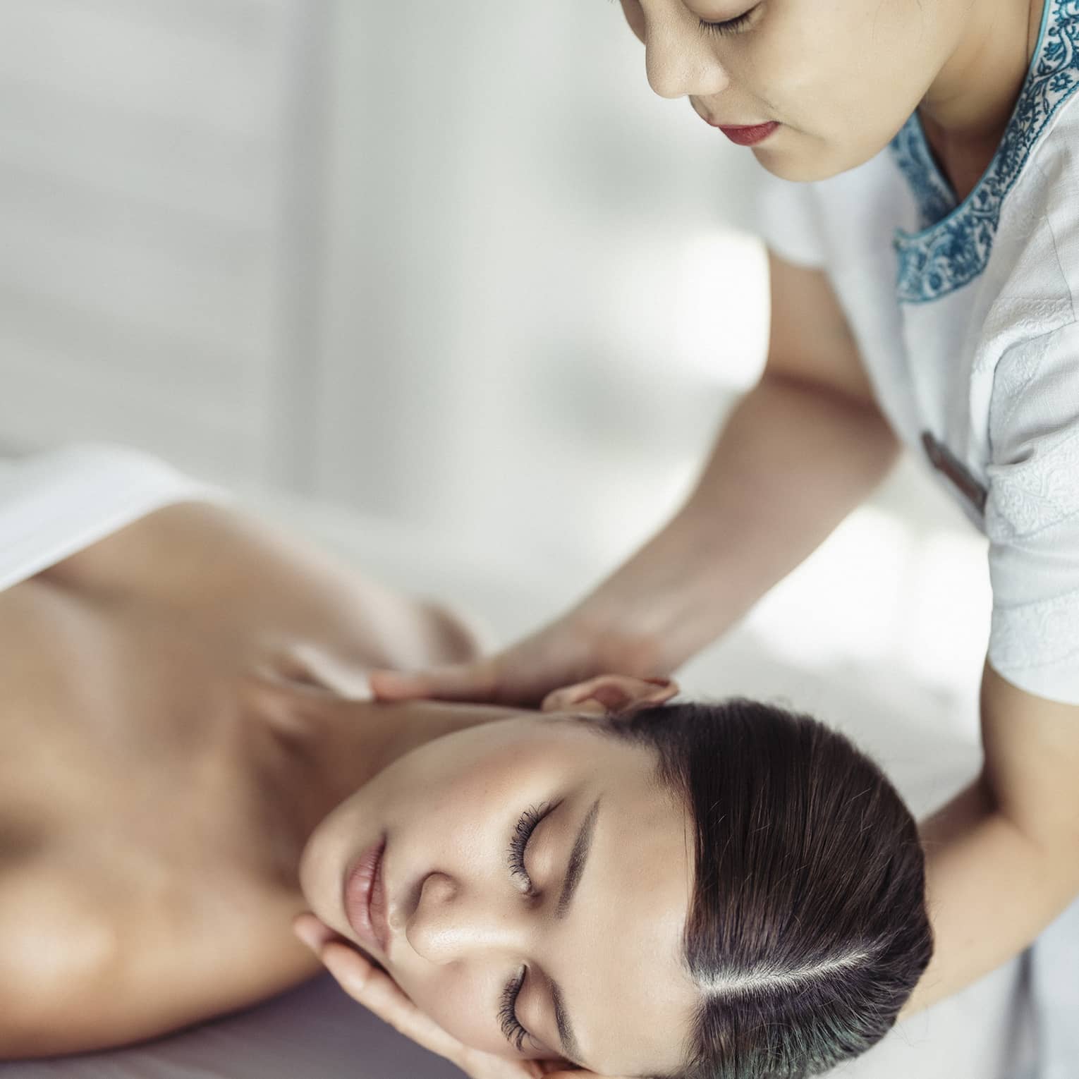 A woman in a spa receiving chiropracty.