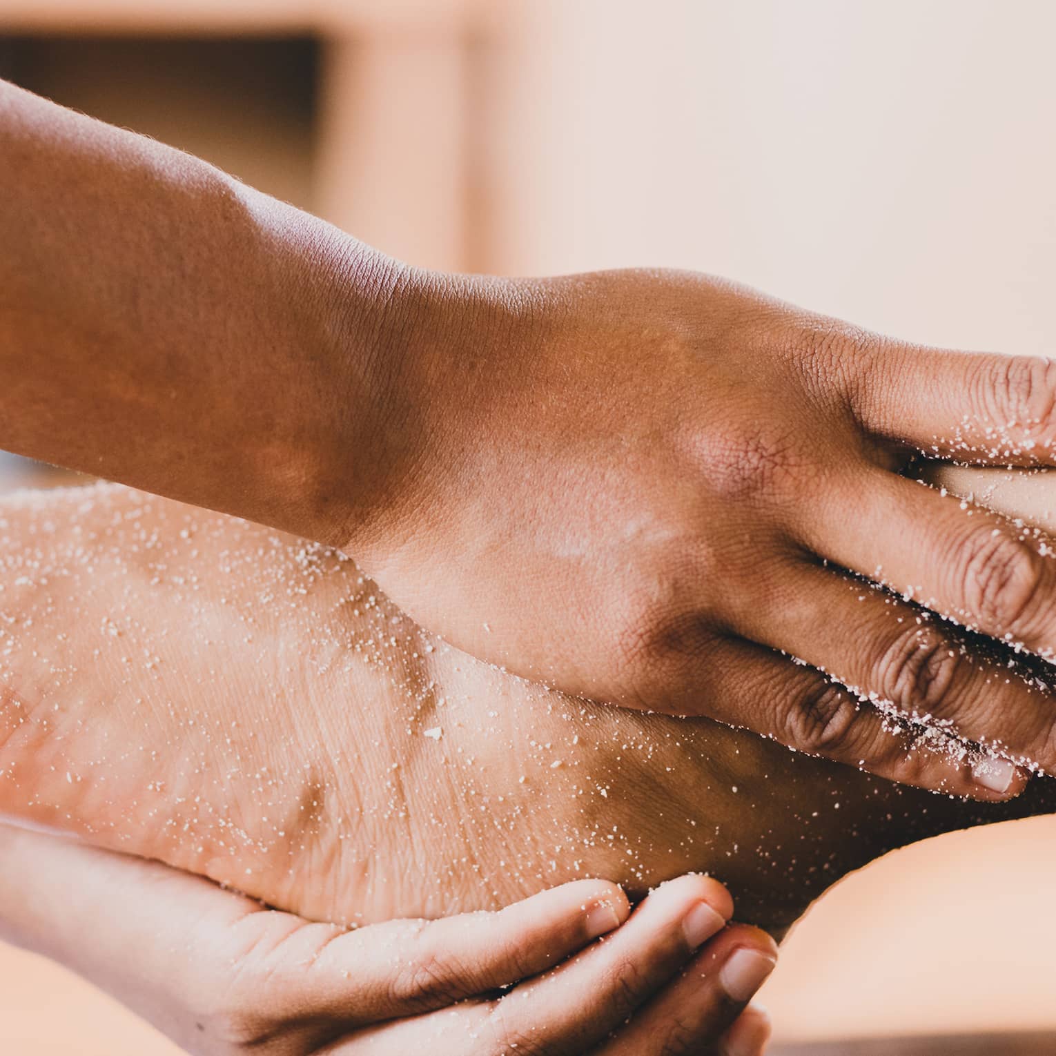 Hands hold a person's foot and ankle in a spa