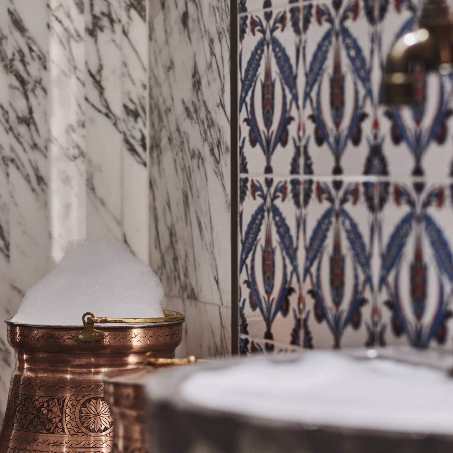 Kuma Spa tiles and marble walls by copper sink