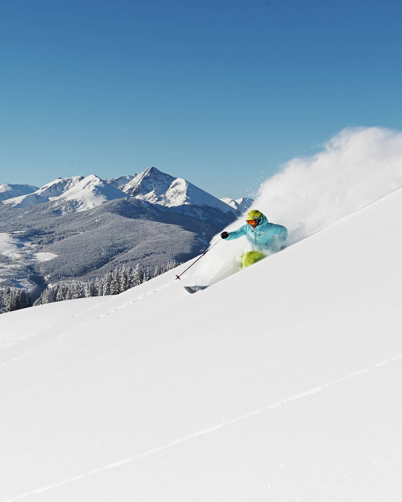 Person skiing down snow covered mountain top