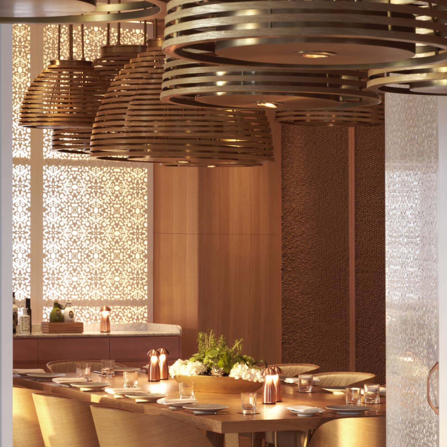 Large overhead lamps hang over a long mahogany table.