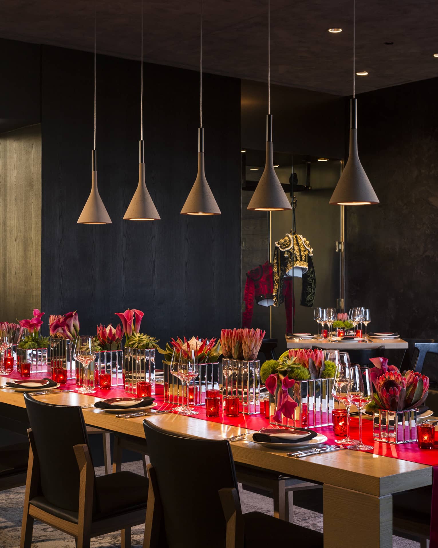 Long table with red runner under row of lamps in San Sebastian private dining room