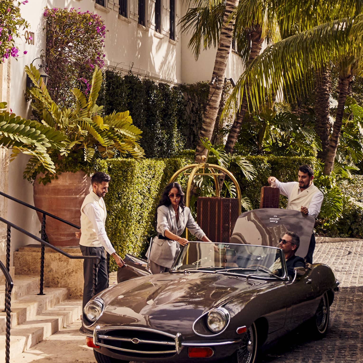 An old car being loaded with luggage.