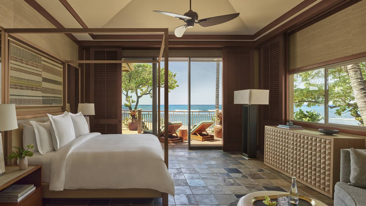 Bedroom with stone tile, four-poster king bed, natural colours, walk-out beach terrace