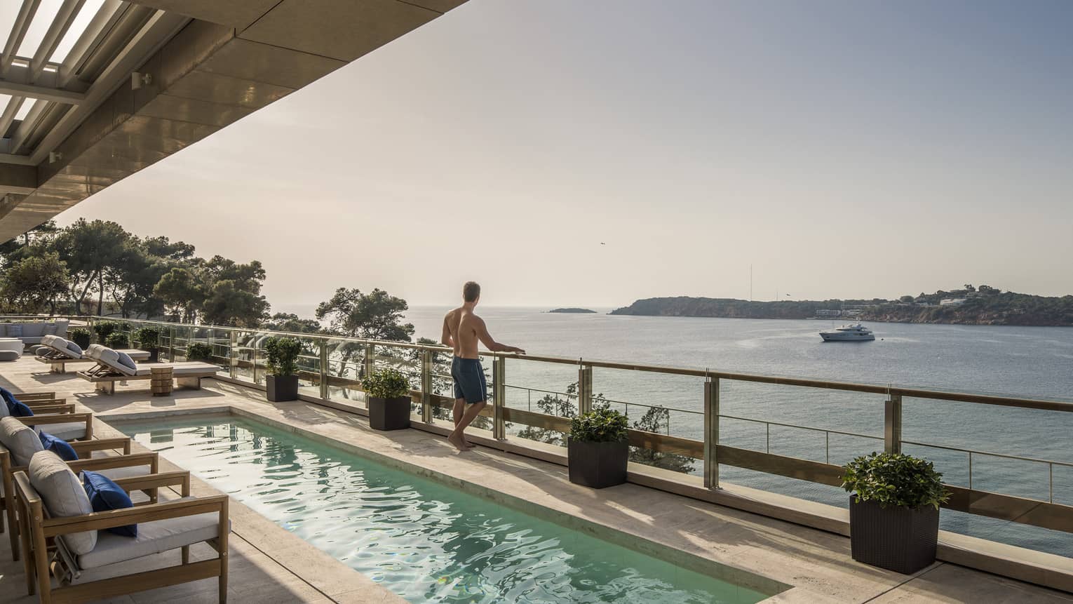 Arion Royal Suite Deck with lap pool and row of lounge chairs, boat on the Mediterranean Sea