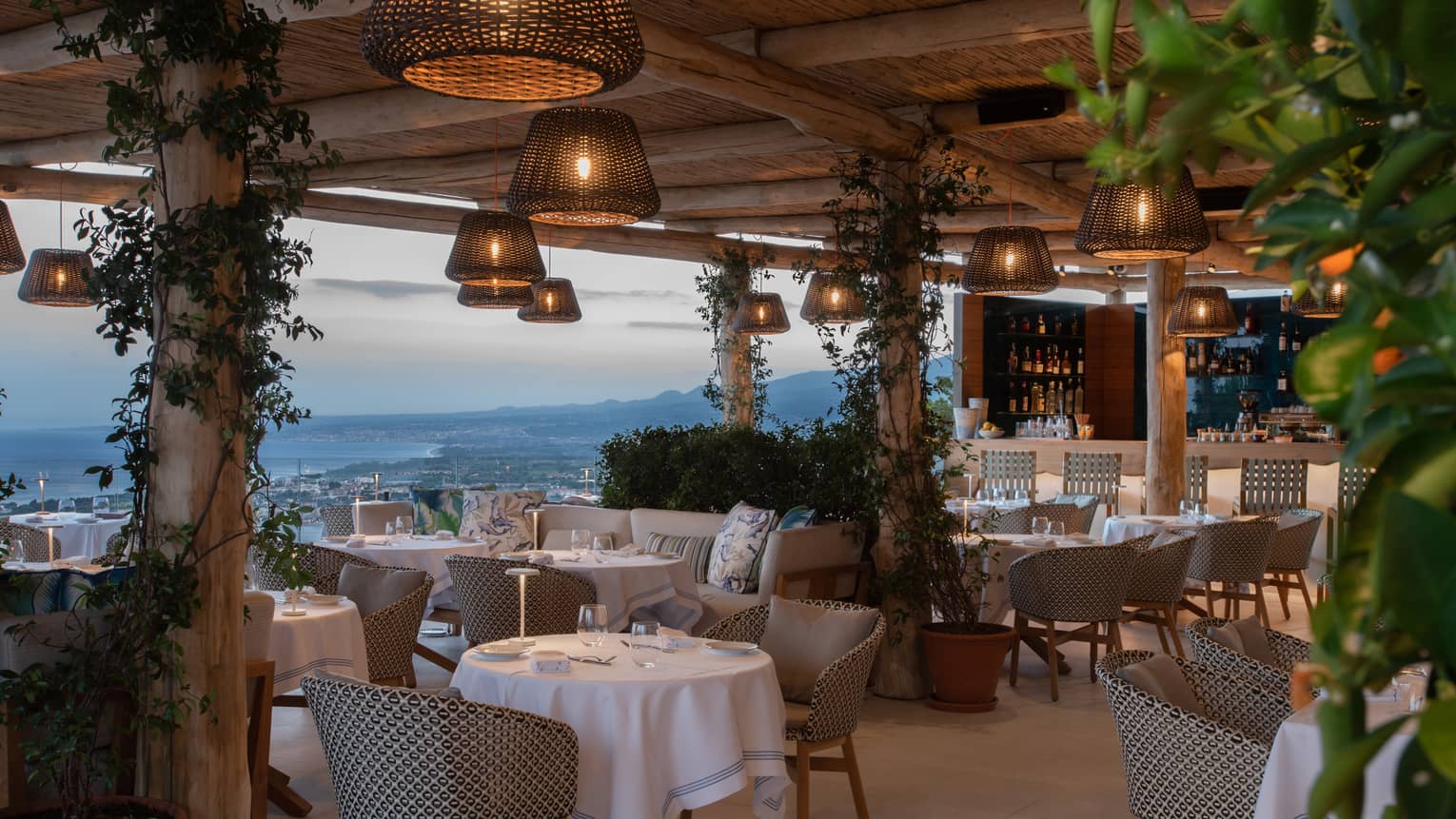Outdoor terrace restaurant with hanging whicker lights, sea view