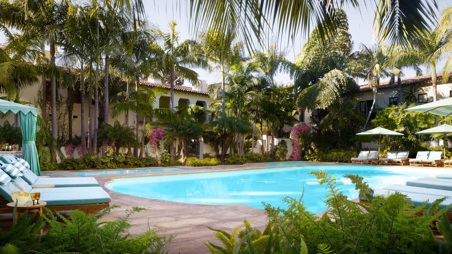 Tropical trees, plants, lounge chairs and cabanas around Jungle Pool
