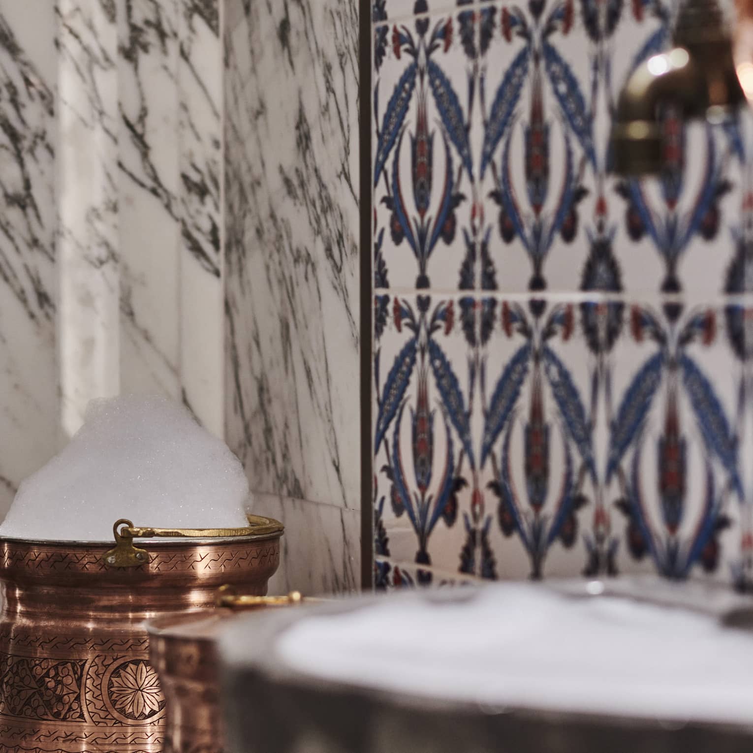 Kuma Spa tiles and marble walls by copper sink