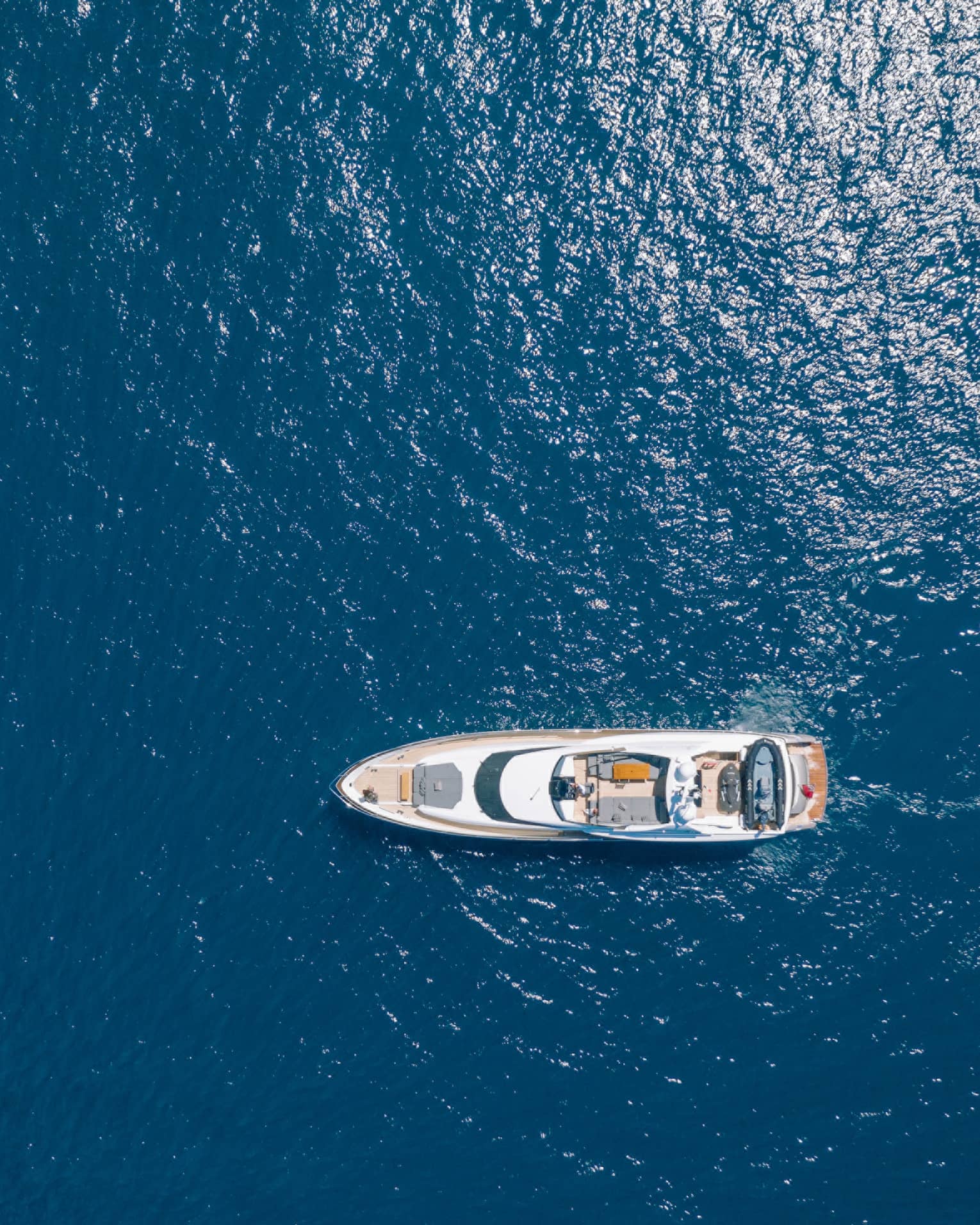 Aerial view of yacht cruising in blue water
